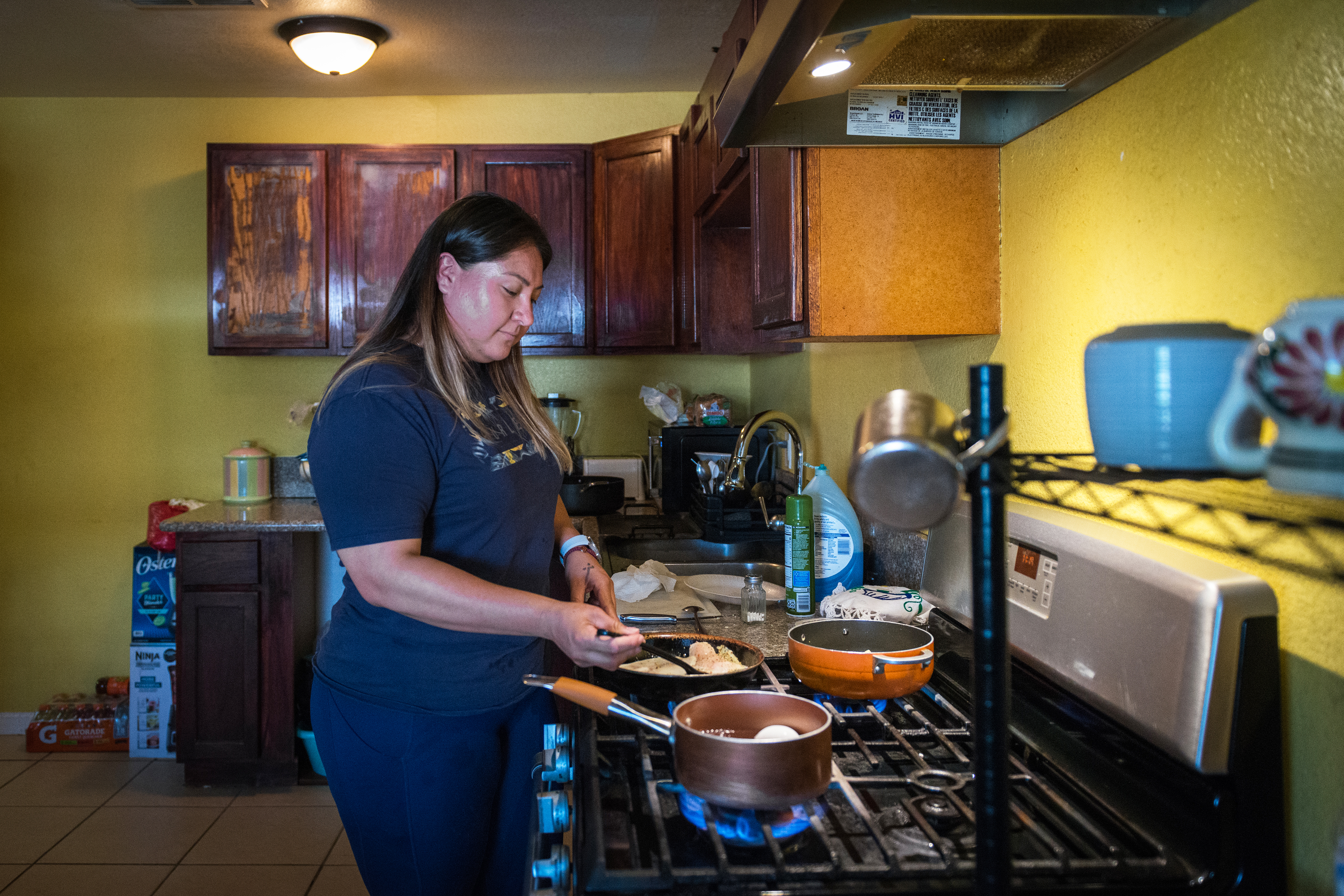 A photo shows Maria Cruz cooking on a stovetop in the kitchen.