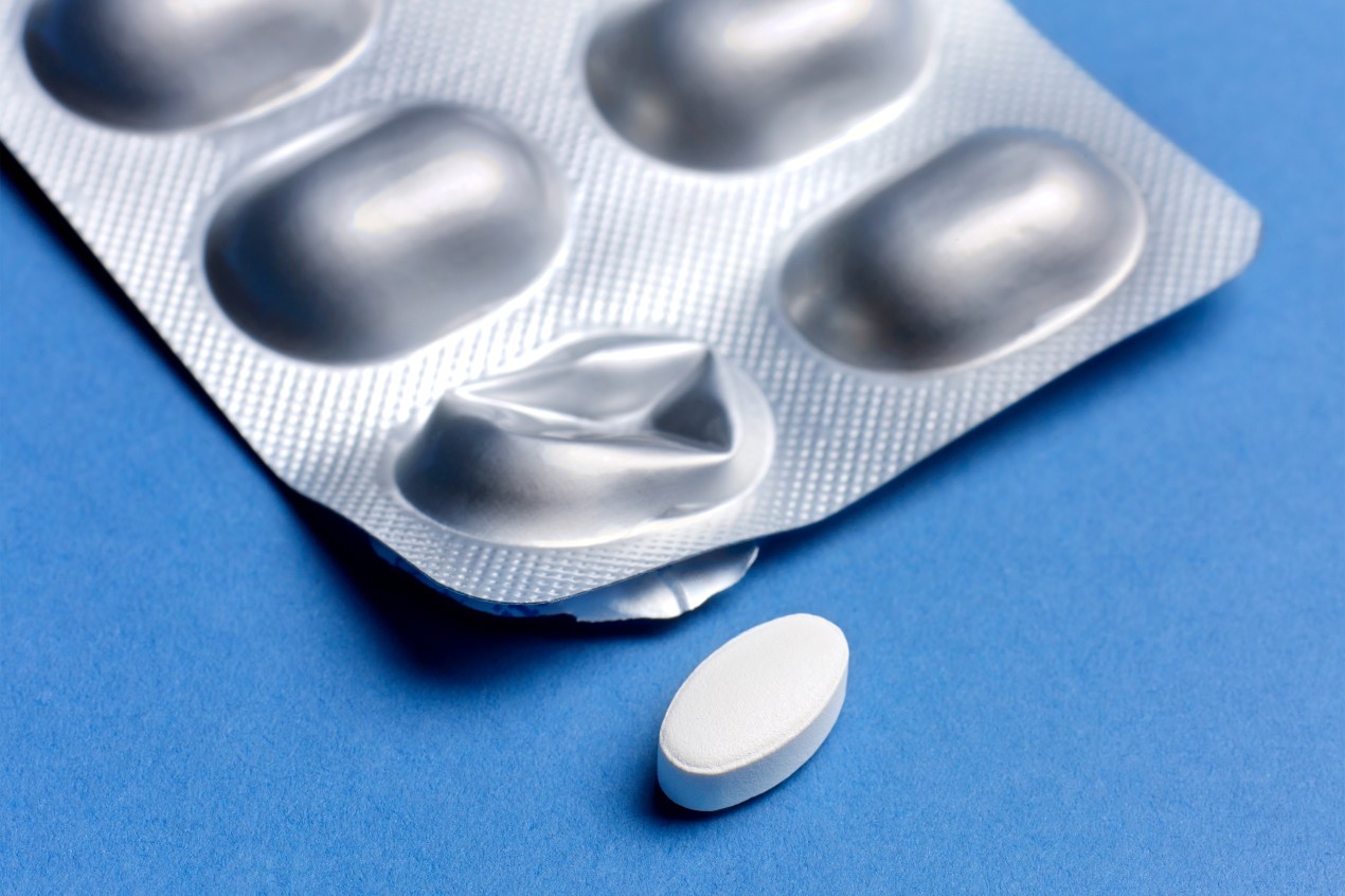 A photo shows a blister pack of pills against a blue background.