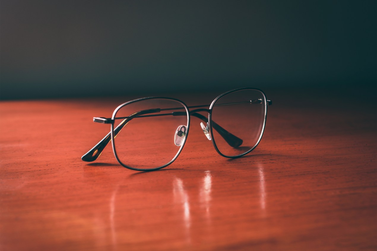 A photo shows a pair of glasses resting on the table.