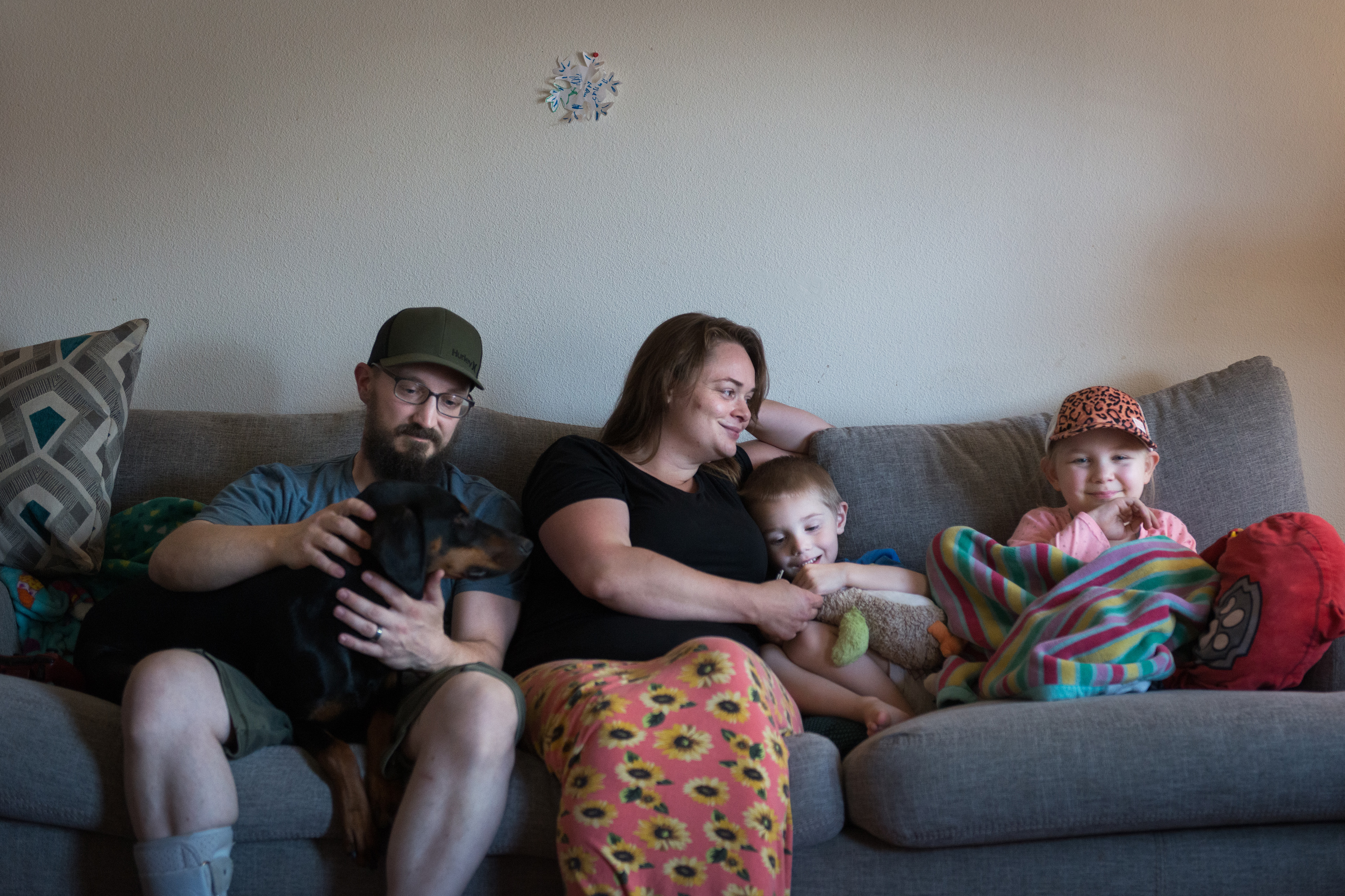 The Lewis family — from left, the father, Spencer, holds their dog on his lap. Beside him is his wife, Deborah, who holds their son, Owen. Their daughter, Annabelle, is wrapped in a colorful blanket to the far right.