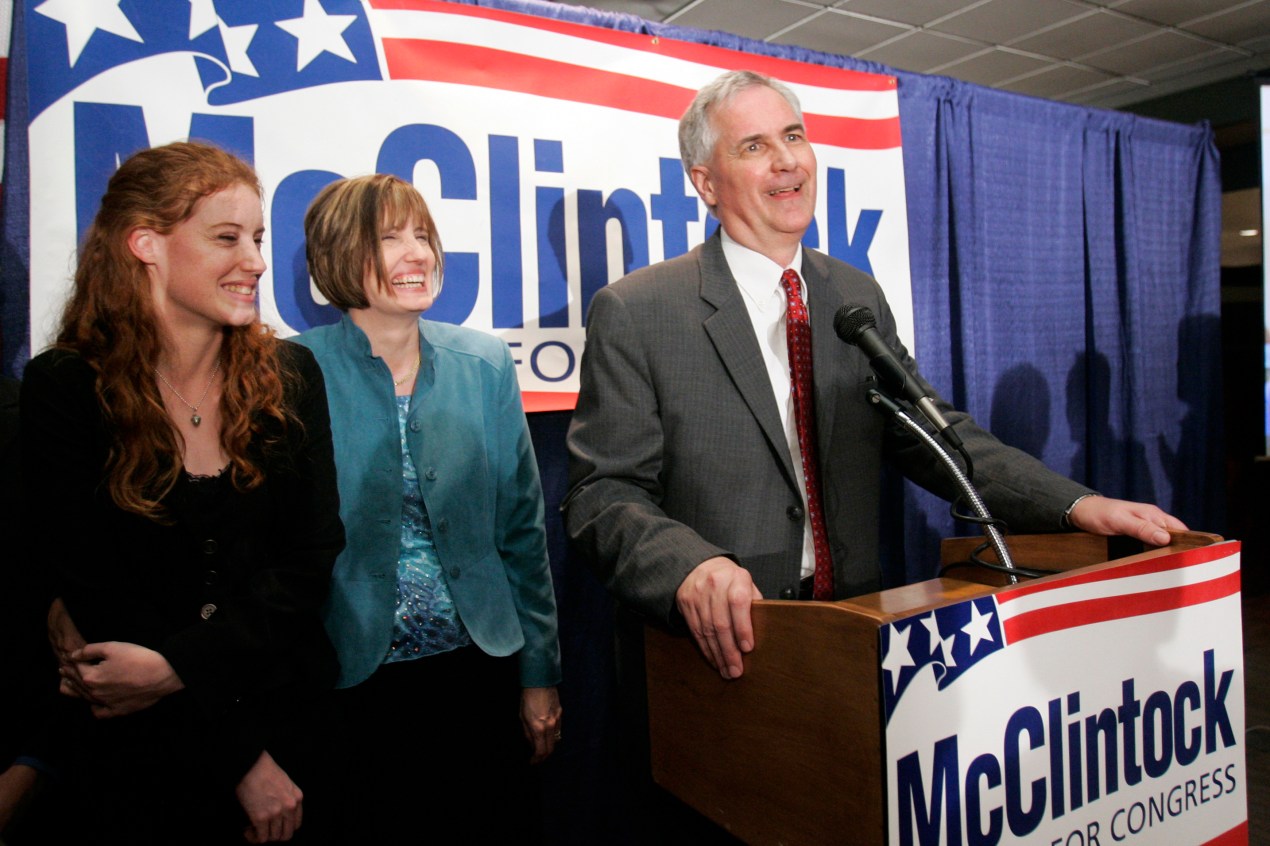 A photo shows U.S. Rep. Tom McClintock, his wife, Lori, and daughter, Shannah, at an event. Signs around them read, "McClintock for Congress."