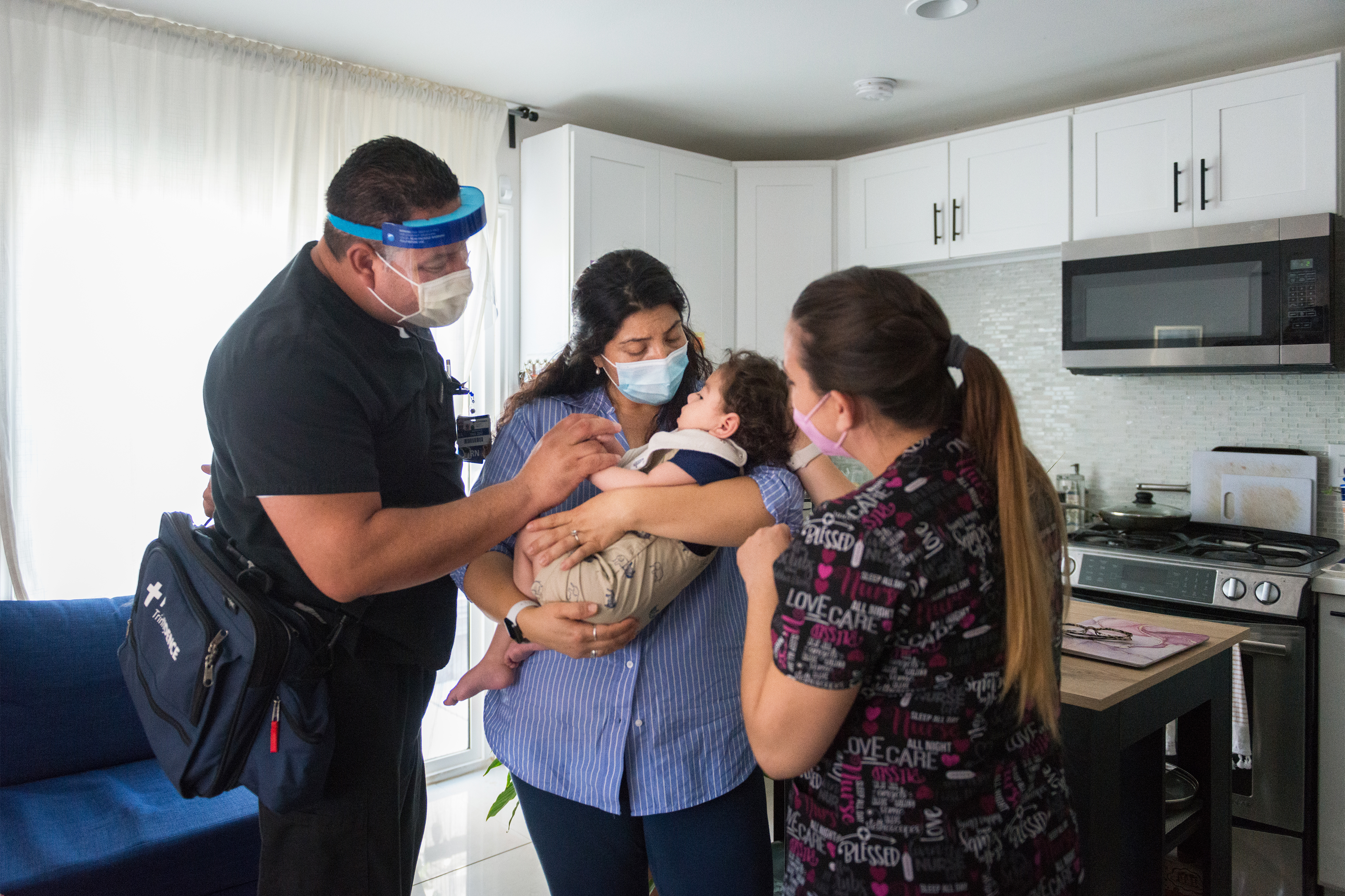 A photo shows two nurses attending to 17-month-old Aaron Martinez while his mother, Adriana Pinedo, holds him.