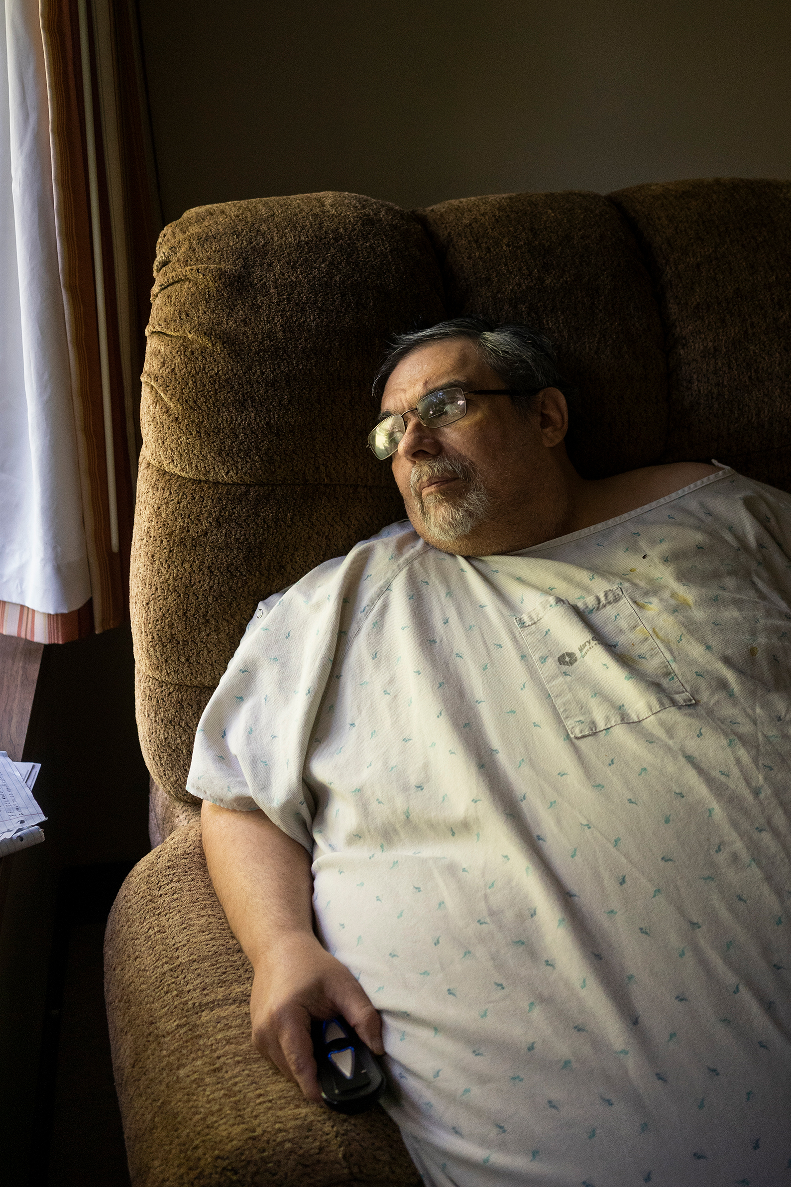 A photo shows Jeff White looking out a window inside of the nursing home where he lives.