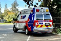 A photo shows an AMR ambulance parked on the side of the road.