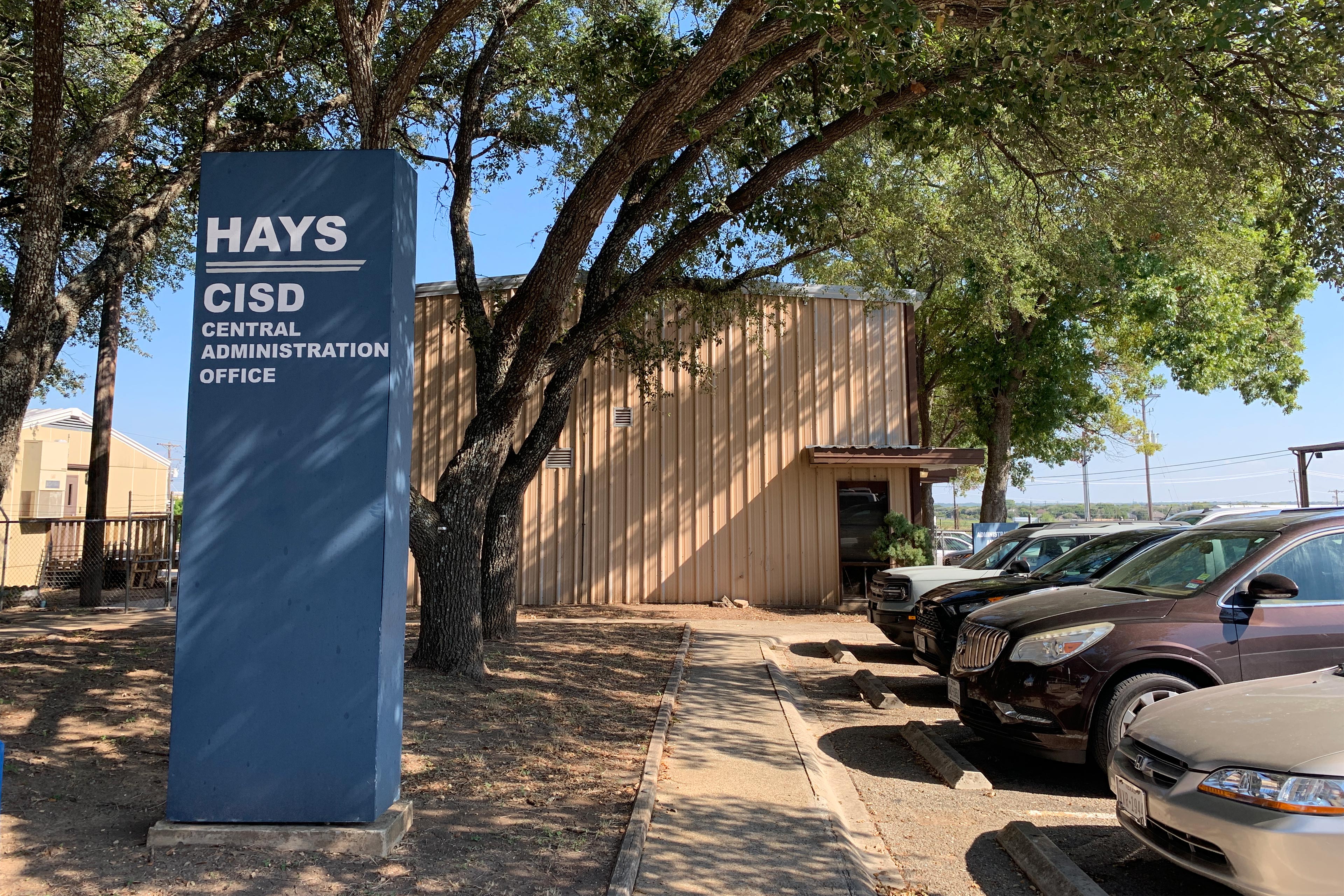 A photo shows the outside of the Hays Consolidated Independent School District's administration office.
