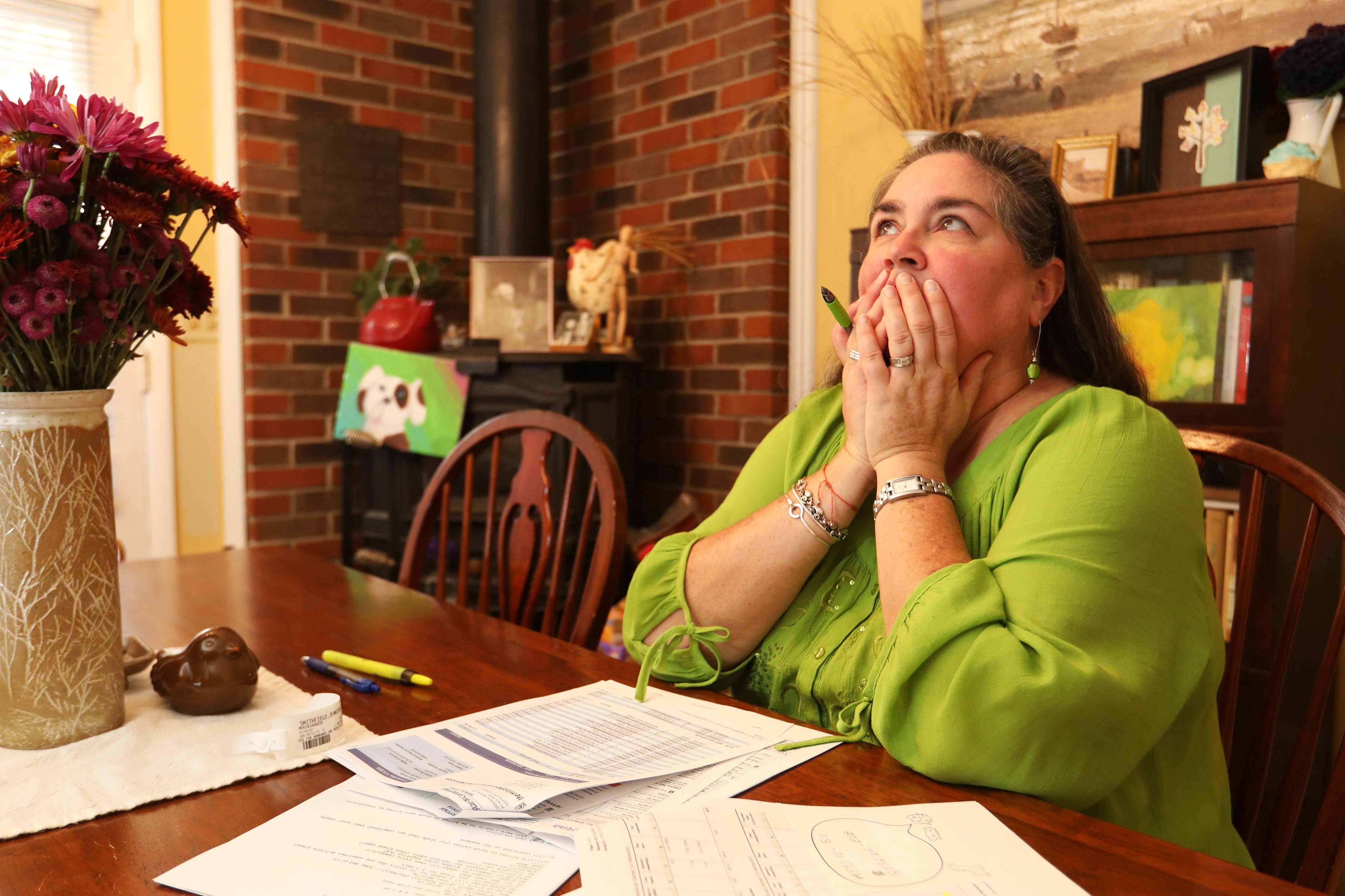 A photo shows Jennifer Smithfield at a table, looking over her medical bills.