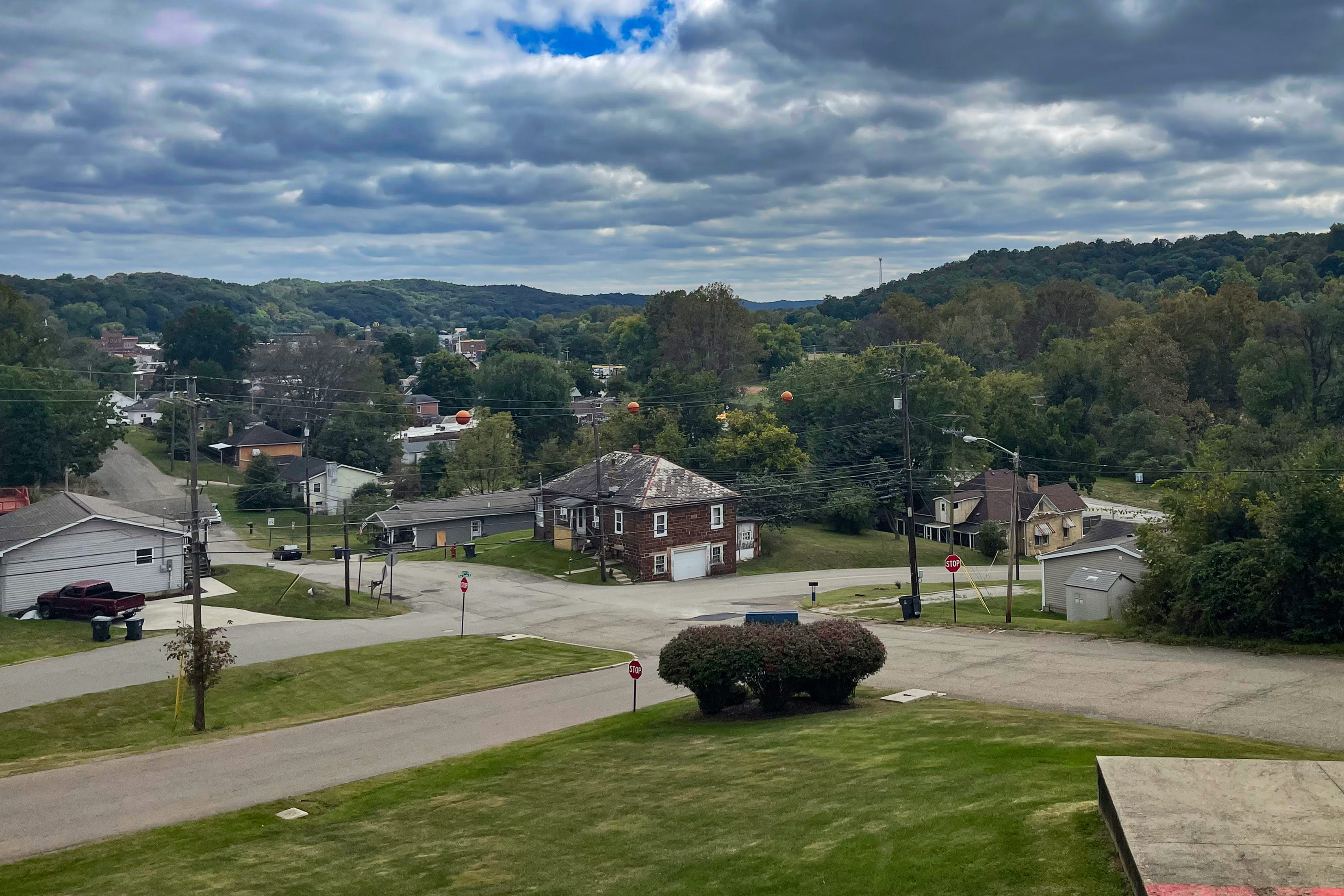 A photo shows a view overlooking downtown Nelsonville in Ohio. It is a grassy, hilly area with wide roads.