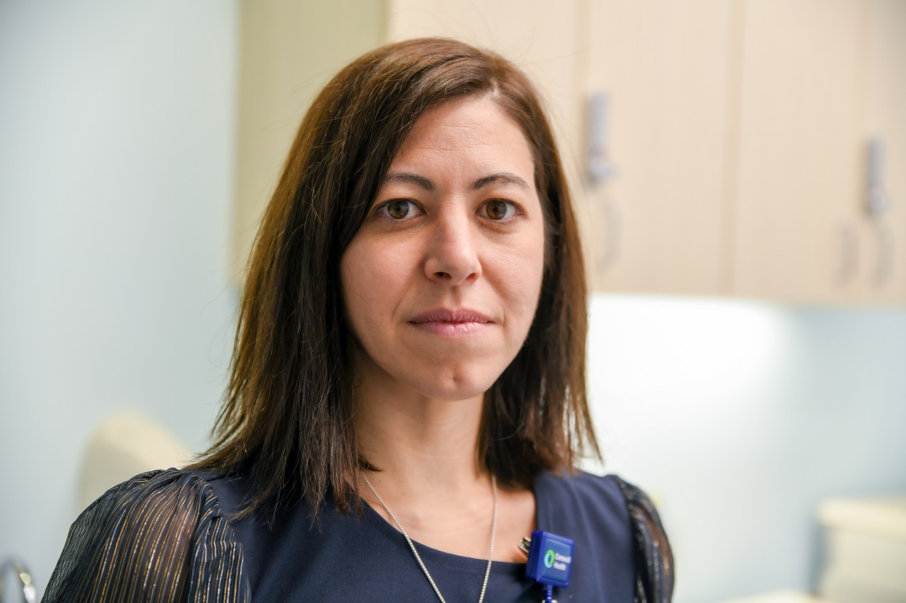 A portrait of Dr. Andrea Hadley, chief of pediatric medicine. She is an adult woman with shoulder-length straight brown hair and is wearing a blue blouse.
