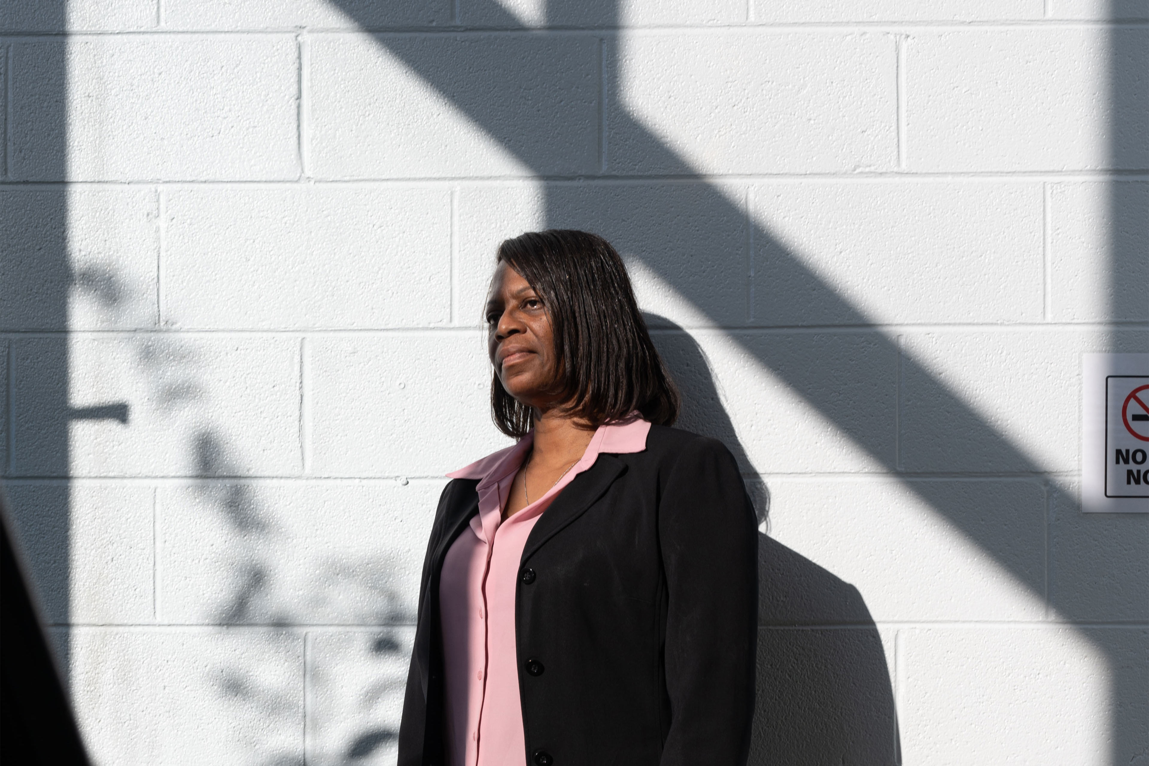 A photo shows Monica Reed standing outside against a white wall.