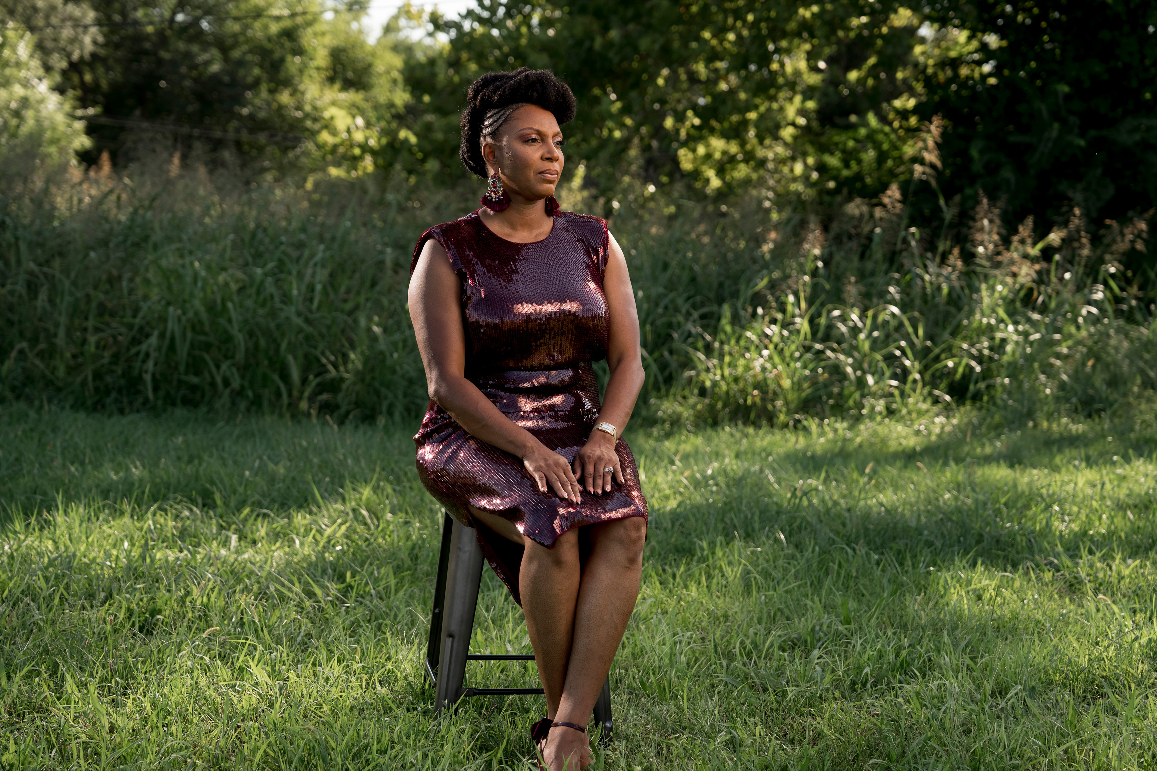 A photo shows Larita Rice-Barnes sitting for a portrait in the field she ran through during a shooting.