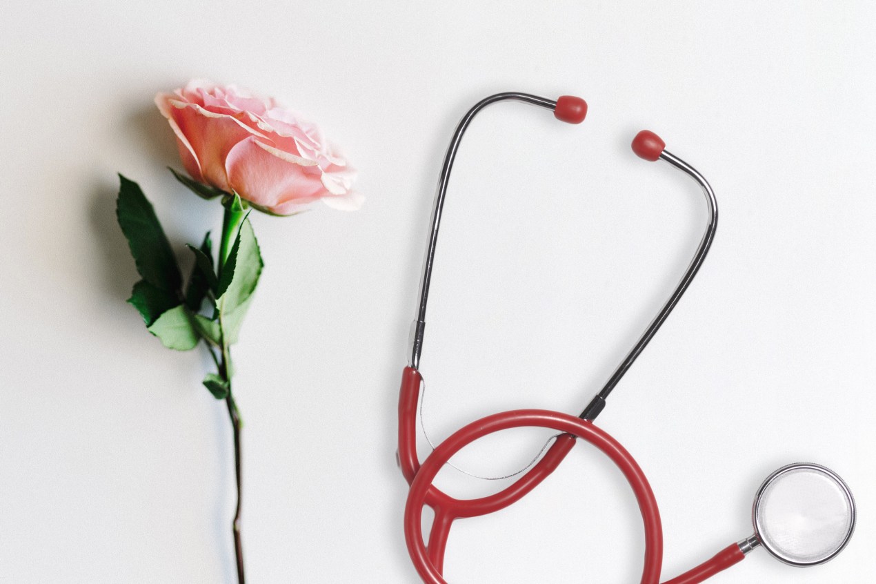 A photo illustration shows a pink rose resting next to a stethoscope.