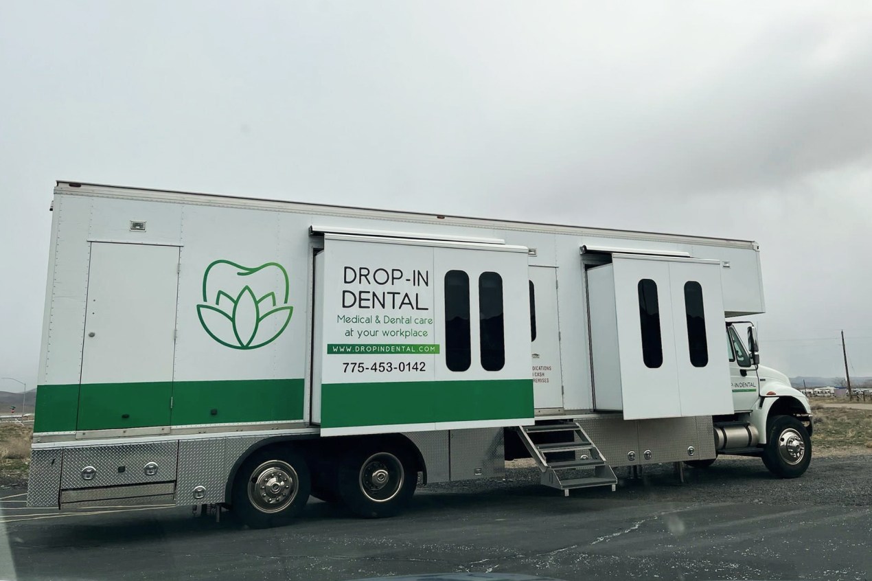 A photo of a mobile dental clinic van outside.