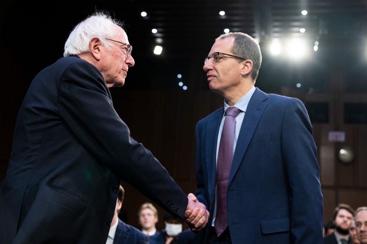 A photo of Senator Bernie Sanders and Moderna CEO Stéphane Bancel shaking hands.