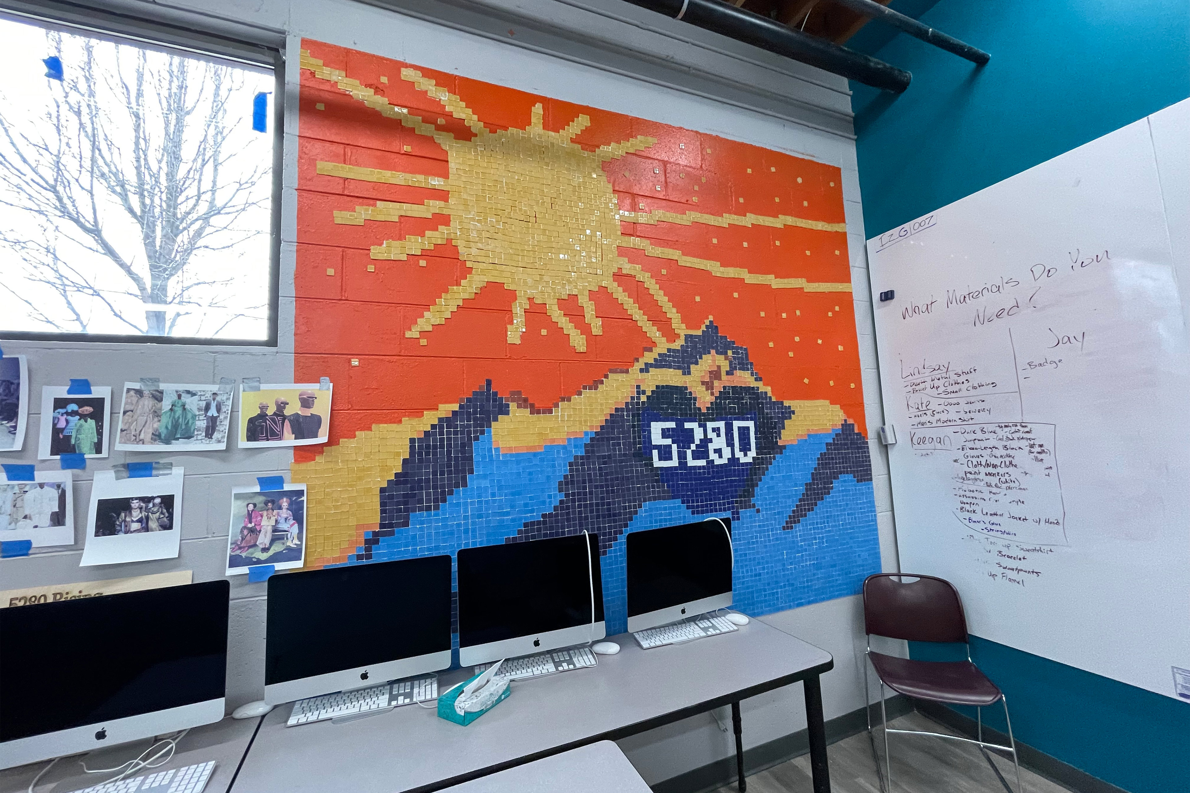 A photo of the inside of a computer lab with a vibrant mosaic of the sun rising over a mountain.