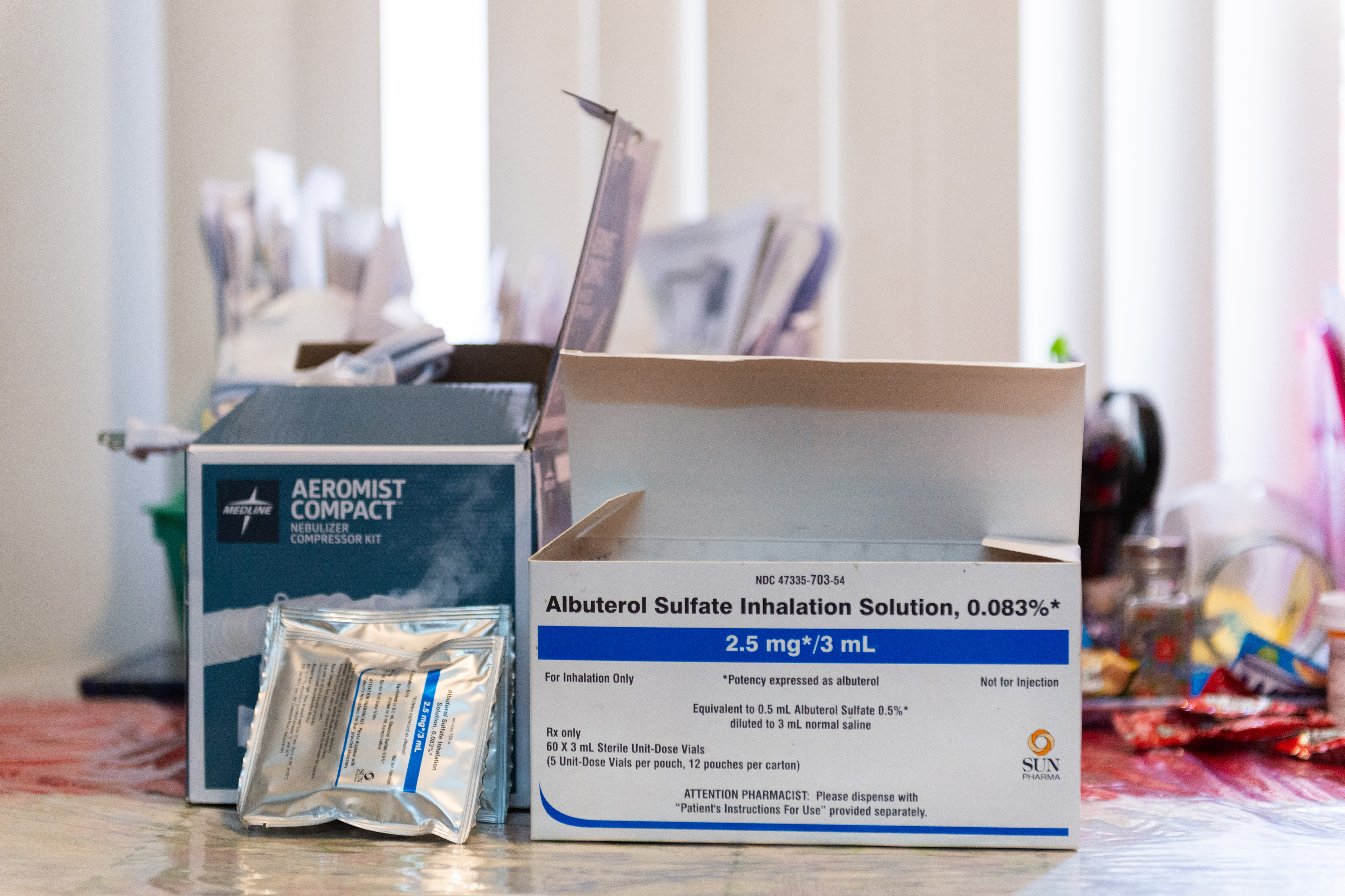 The photograph shows a box of medication Lucas takes for his lung cancer. It is a white box with blue lettering that reads, "Albuterol Sulfate Inhalation Solution." A nebulizer compressor kit is also visible.