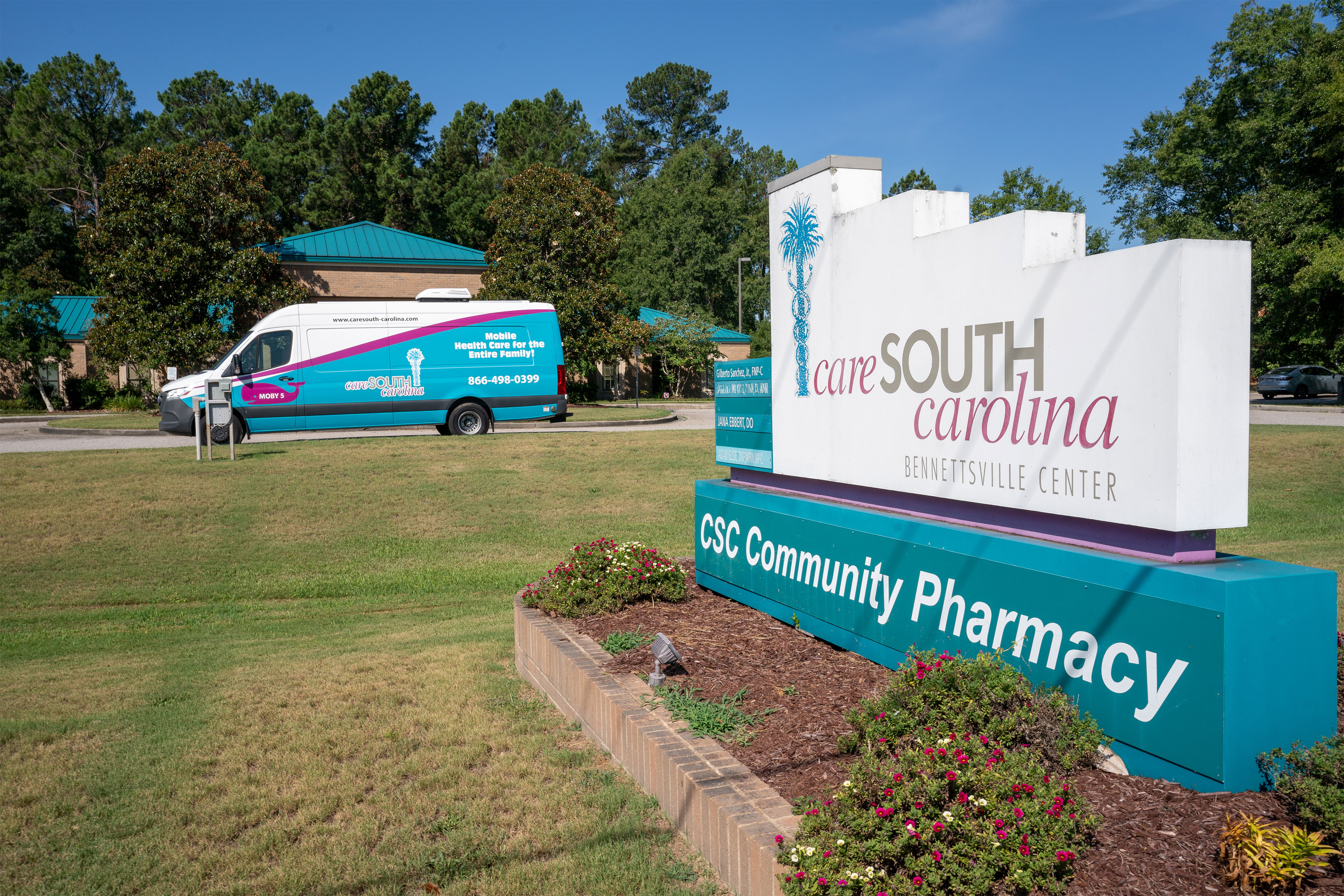 A momument sign reads "care SOUTH carolina", "Bennettsville Center", and "CSC Community Pharmacy". About 50 feet beyond the sign is a parked van also marked "care South carolina".