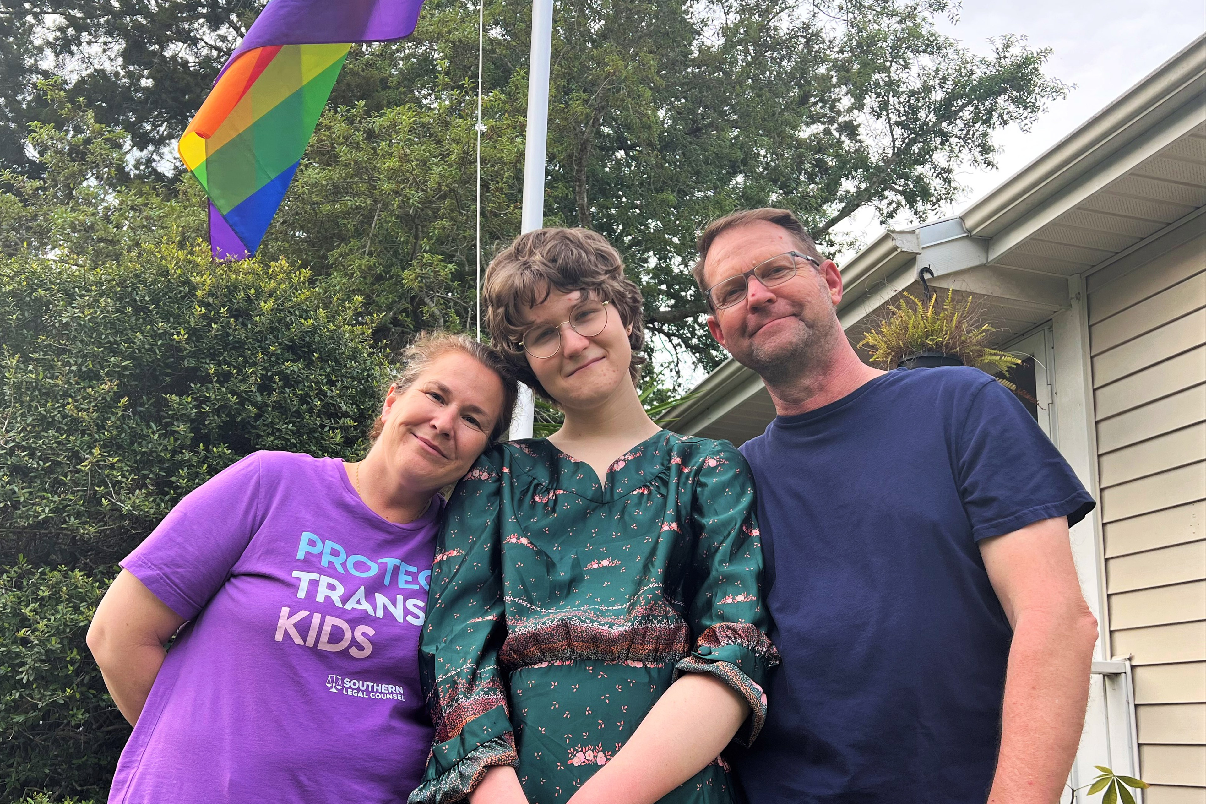 A photo of Josie with her parents outside.