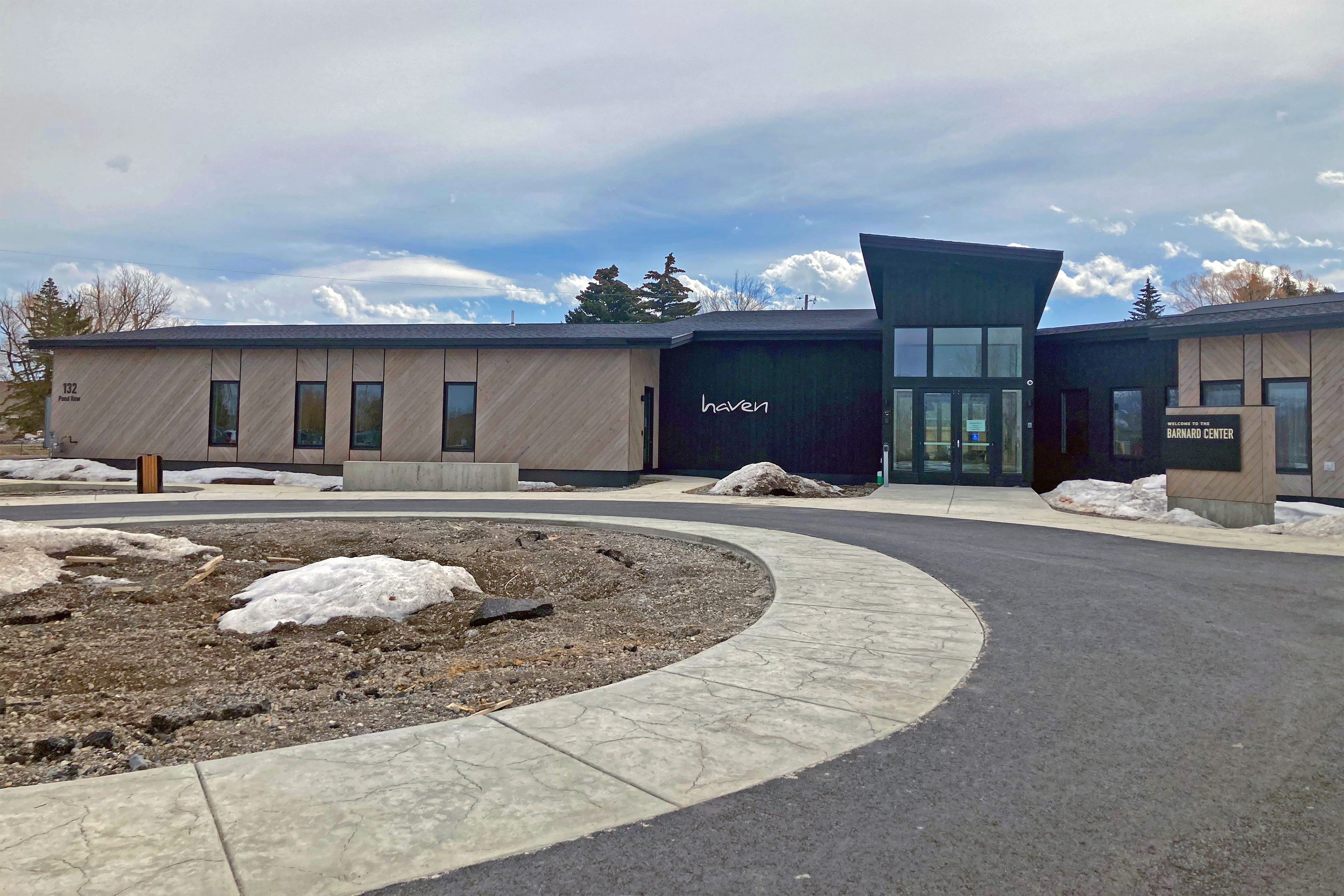 "Haven" can be read on the exteiror of a building. There are some small mounds of snow in the center of the circular driveway and beside the entrance to the building.