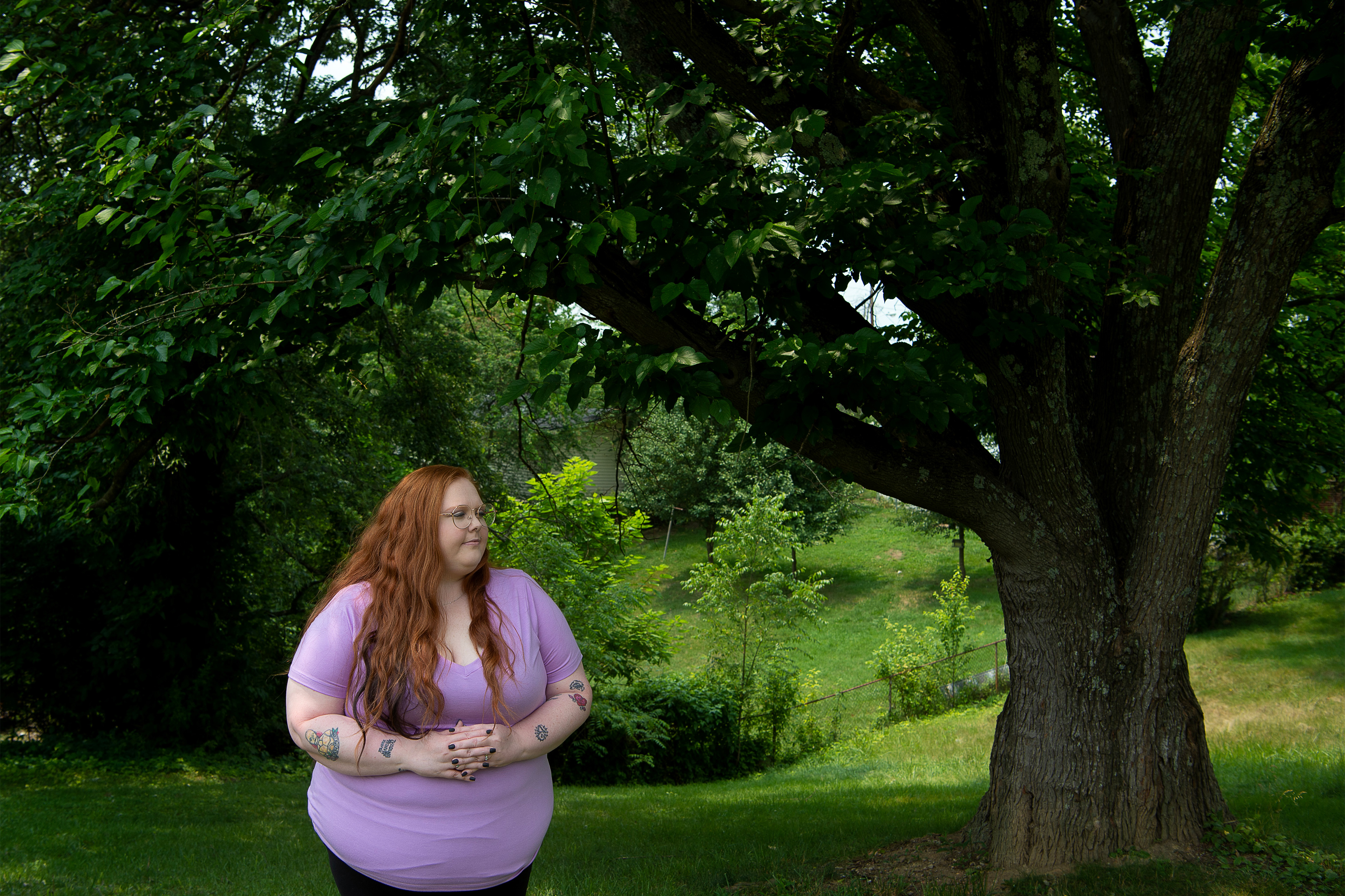 A photo of Bethany Birch standing outside by a tree.