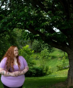 A photo of Bethany Birch standing outside by a tree.