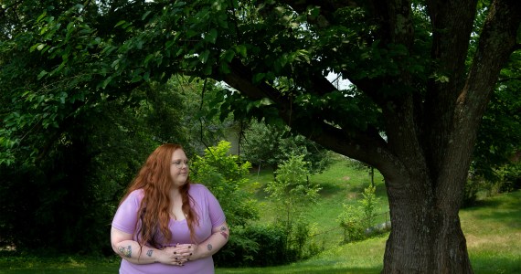 A photo of Bethany Birch standing outside by a tree.