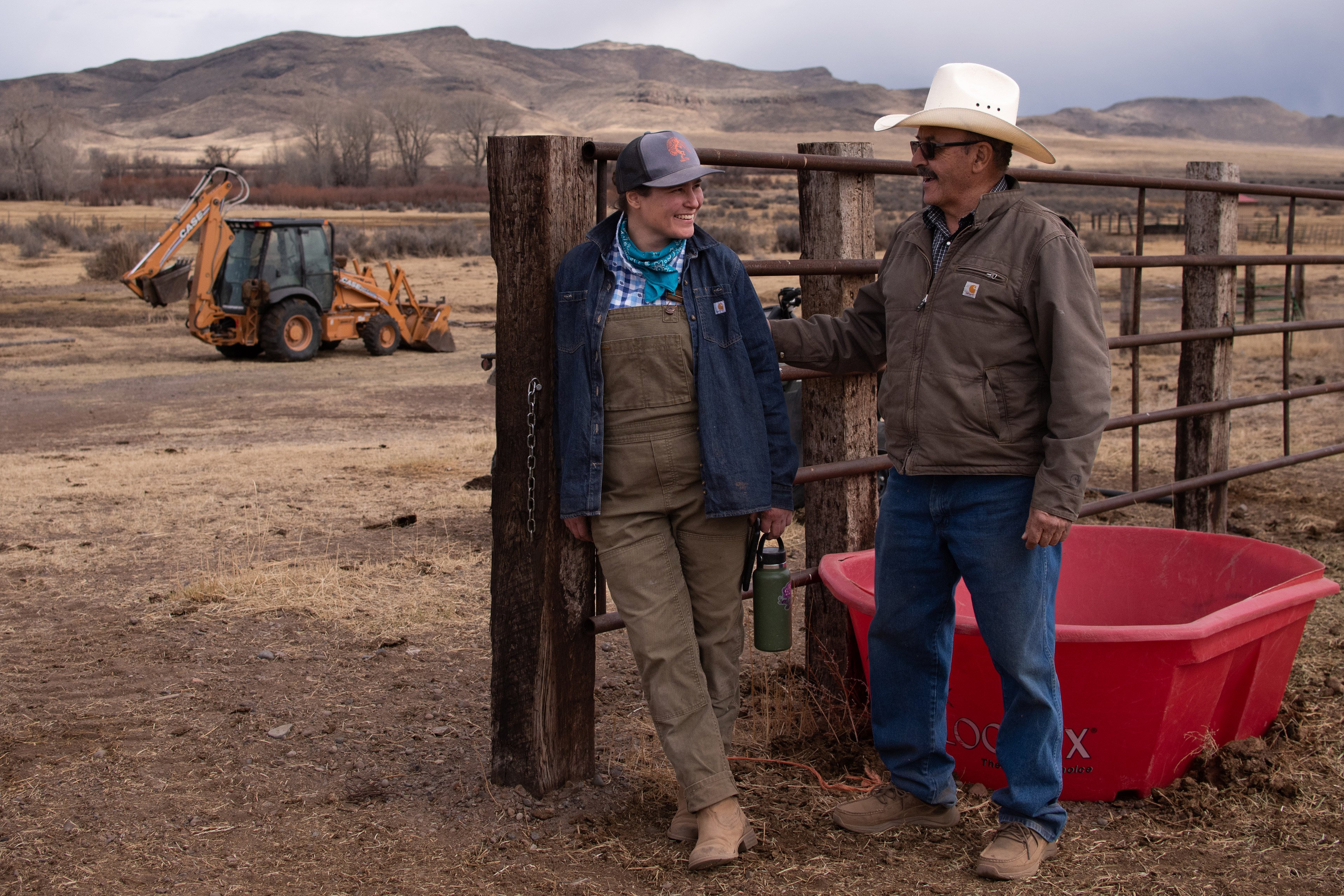 A photo of John and Angie Mestas talking outside by a fence.