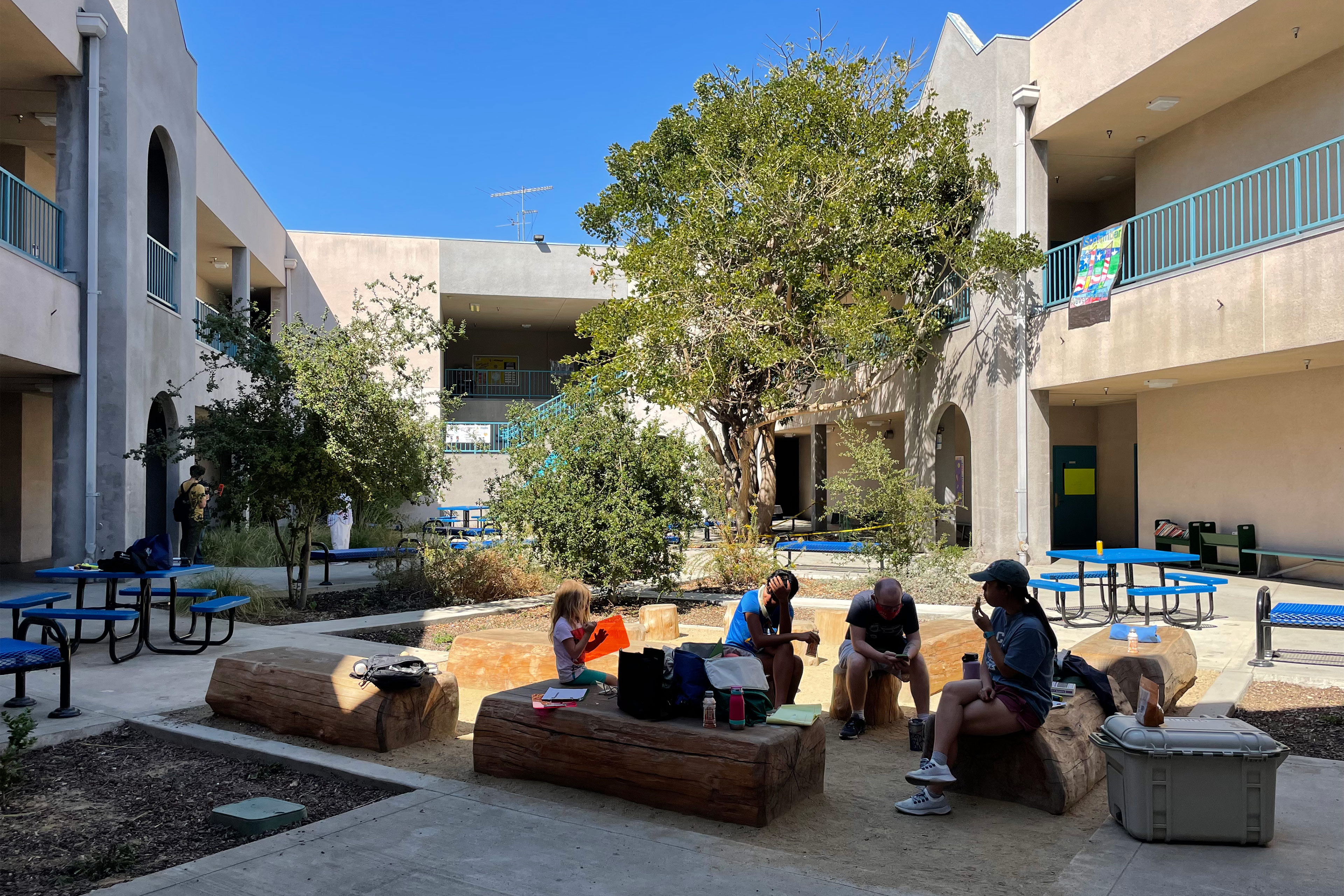 A photo of people sitting in a shaded courtyard.