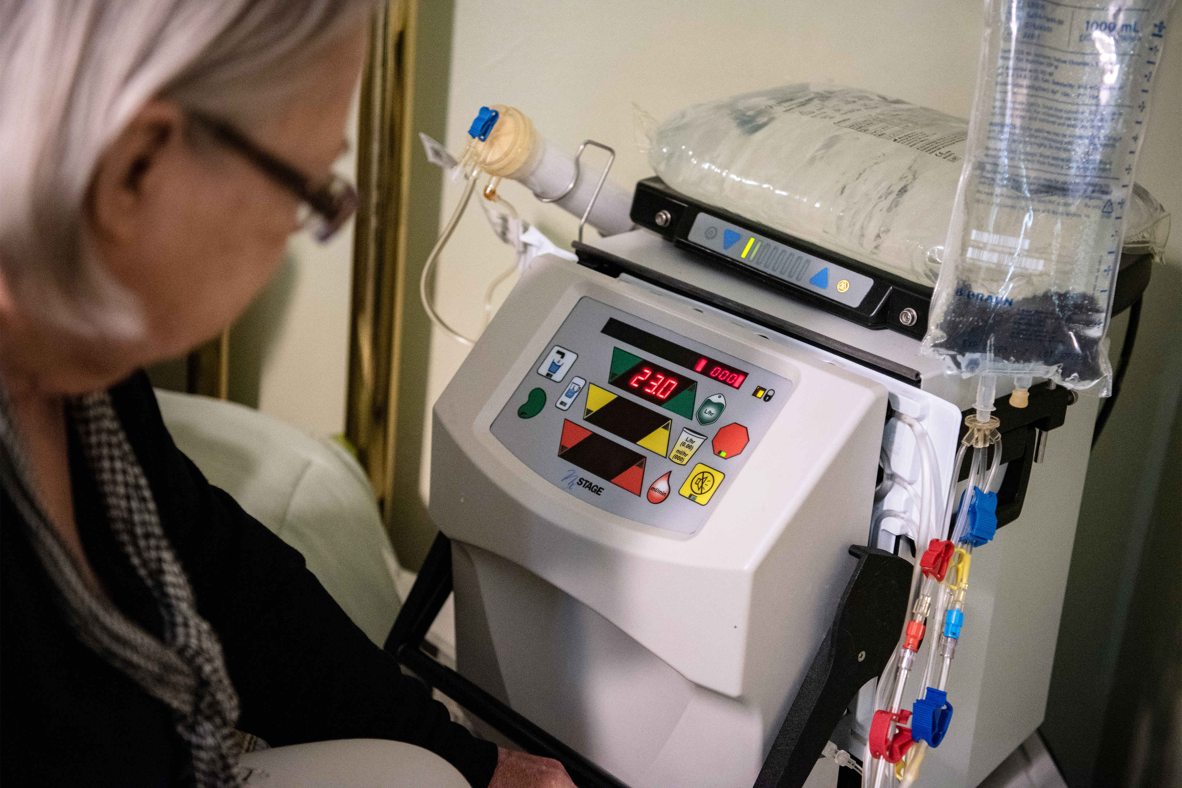 A photo of a hemodialysis machine resting on a bedside table.