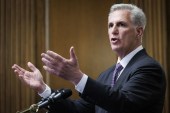 A photo of House Speaker Kevin McCarthy speaking at a podium while gesturing with his hands.