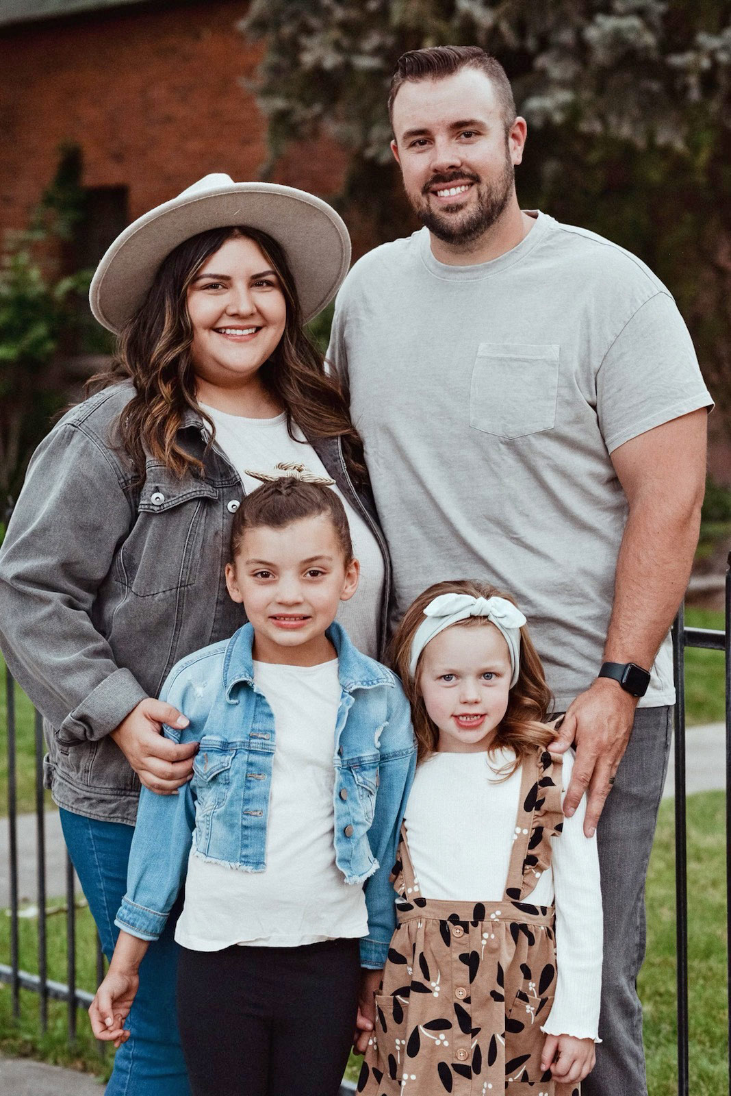 A family photo of a husband, wife, and two young daughters.