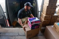 Medical courier Dru Roberts loads disposable diapers and medical supplies into a delivery van at the Health Aid Warehouse on June 13, 2023, in Tampa, Florida.