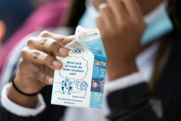 A student holds a milk carton at lunch at Burke County High School in Waynesboro, Georgia Wednesday, November 3, 2021. According to the U.S. Department of Agriculture, a school meal is not reimbursable without milk. (Photo by Sean Rayford for The Washington Post via Getty Images)