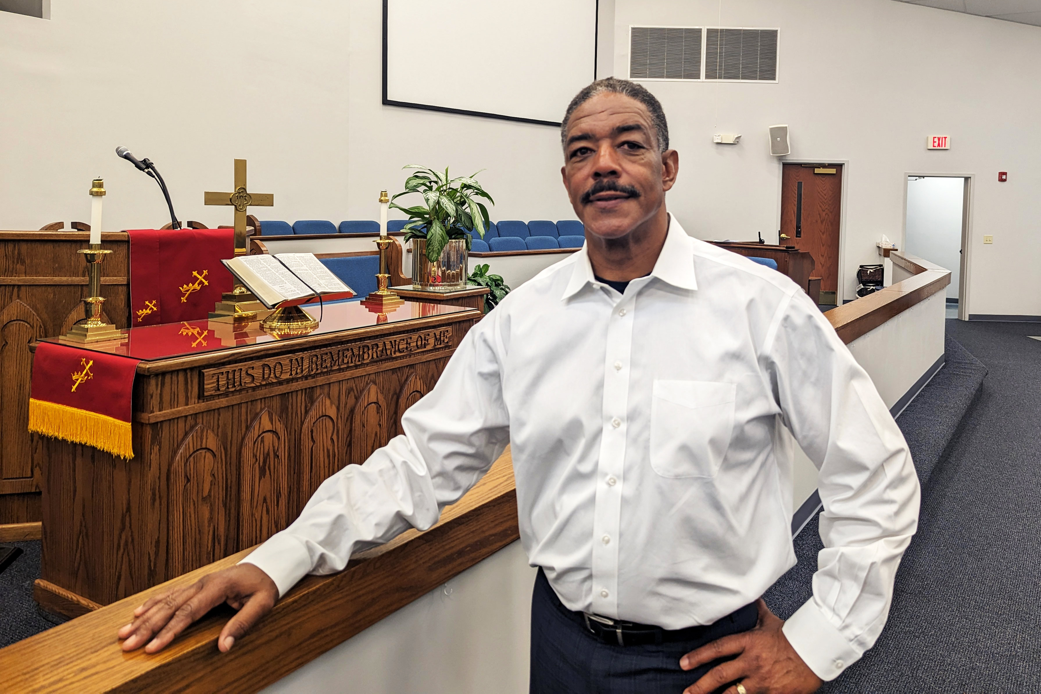 A photo of a reverend standing inside a church.