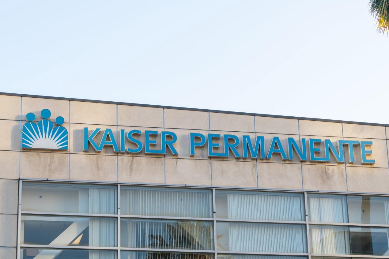 The Kaiser Permanente logo is seen on the facade of a building.