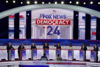 A wide shot of the Republicans present for the first debate of the 2024 presidential race. Behind them is large text that reads, "Fox News, Democracy 24."