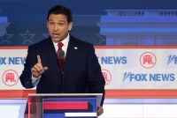 A photo of Ron DeSantis speaking at a debate while gesturing with his hand.
