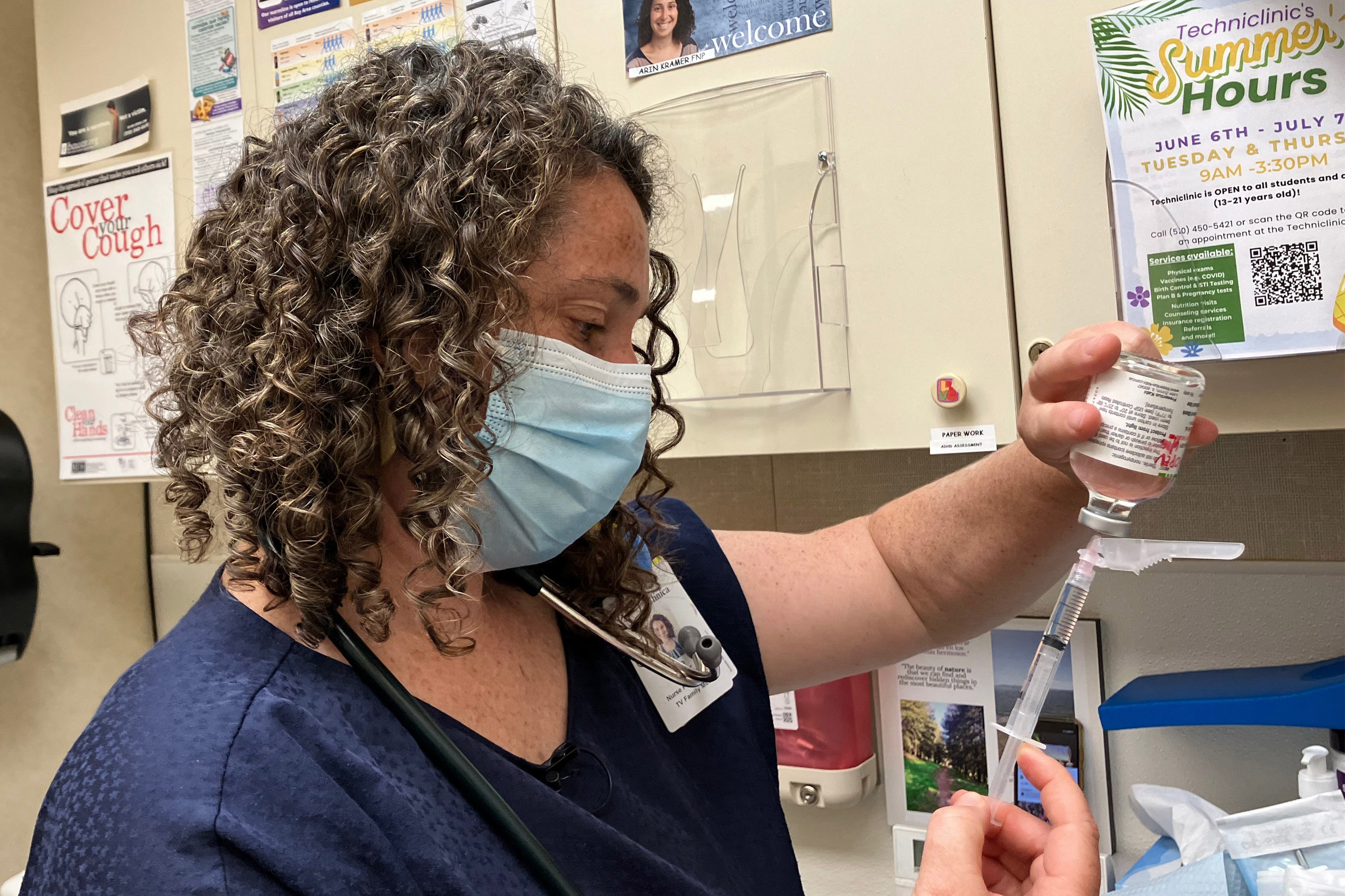 A photo of a woman preparing a syringe.