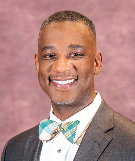 A photo of a Black man posing for a portrait.