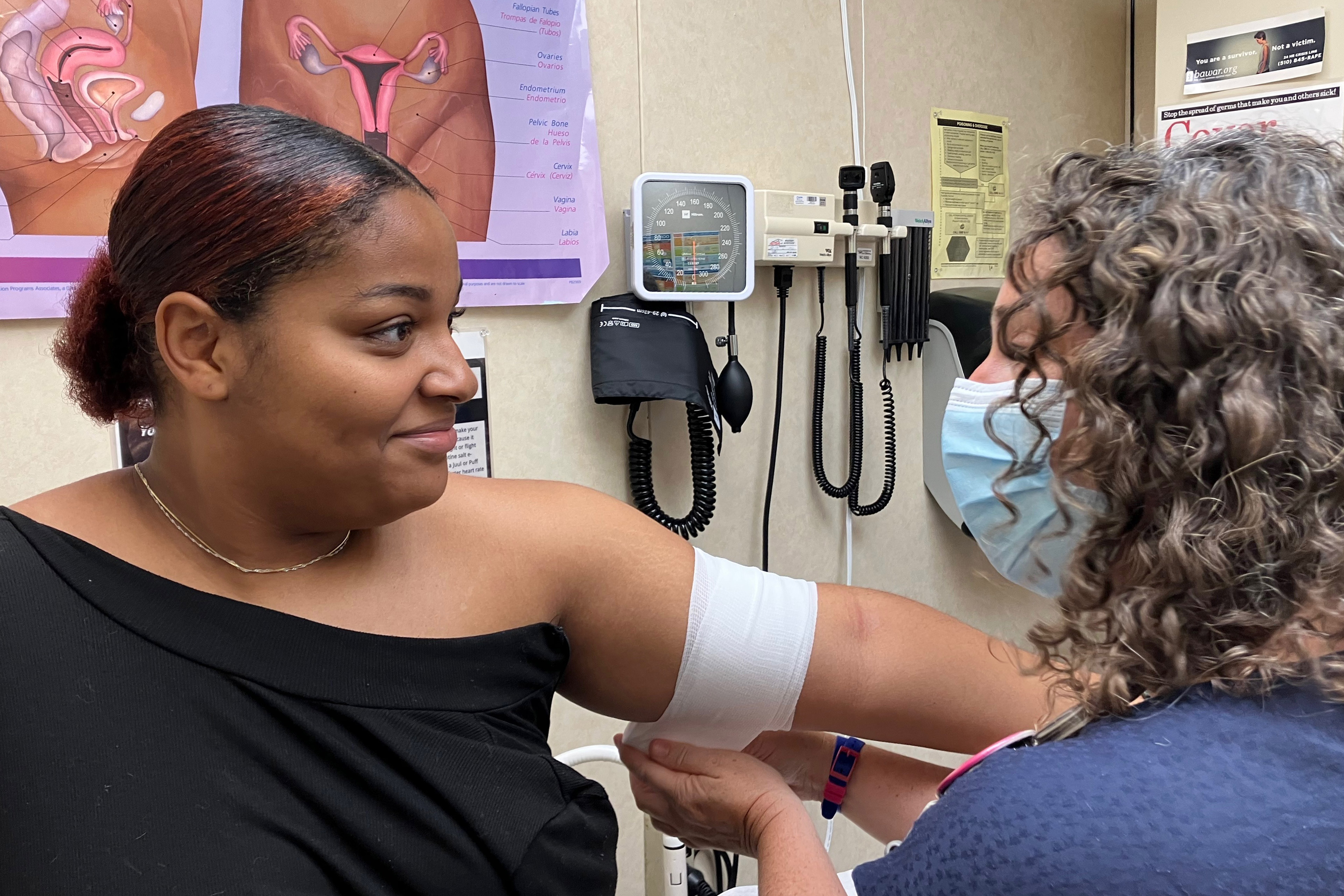 A photo of a nurse practitioner bandaging a woman's arm.