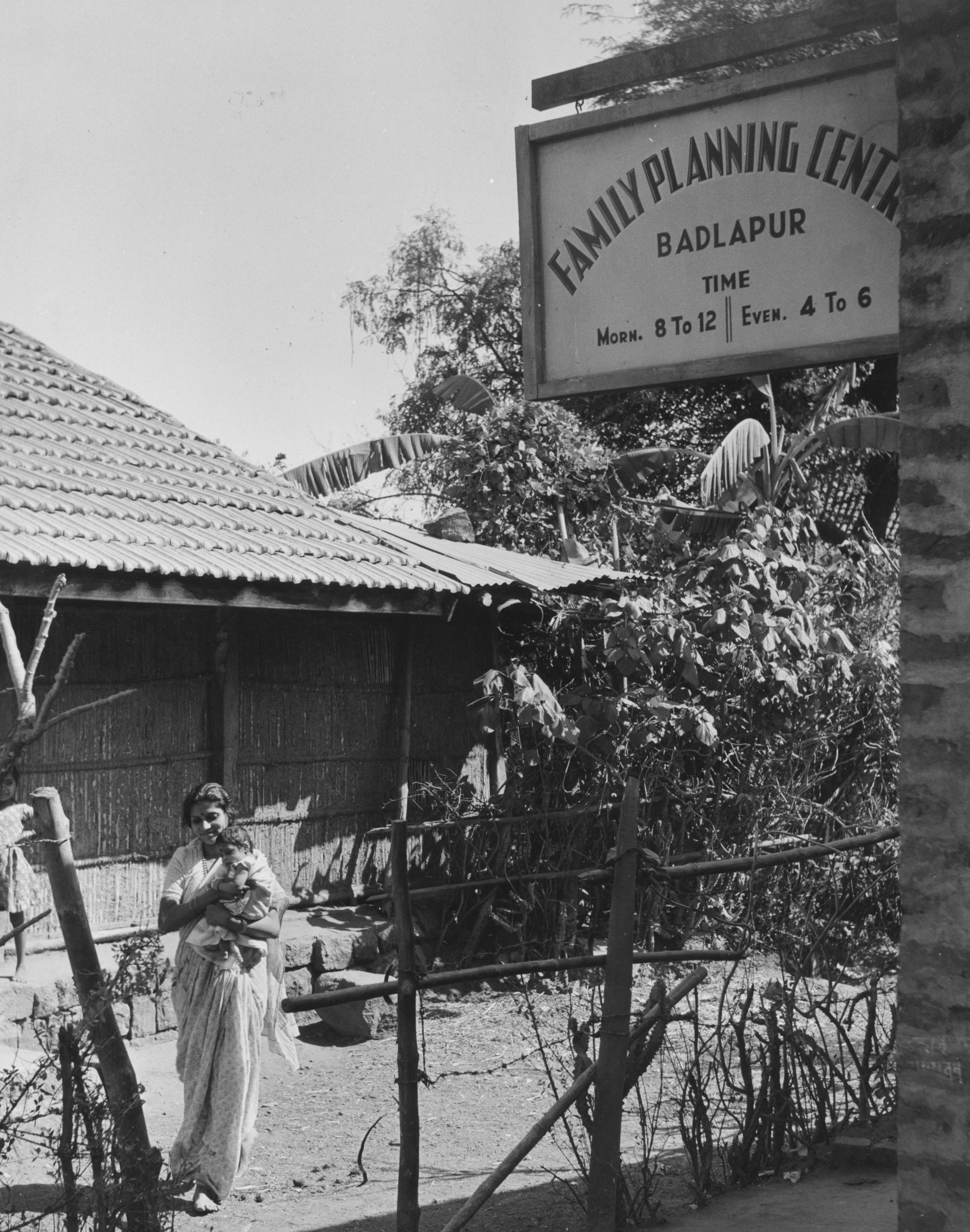 A woman carries a baby outside the family planning center in the village of Badlapur in 1954.