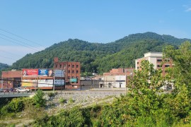 A photo of a downtown area with mountains seen in the background.