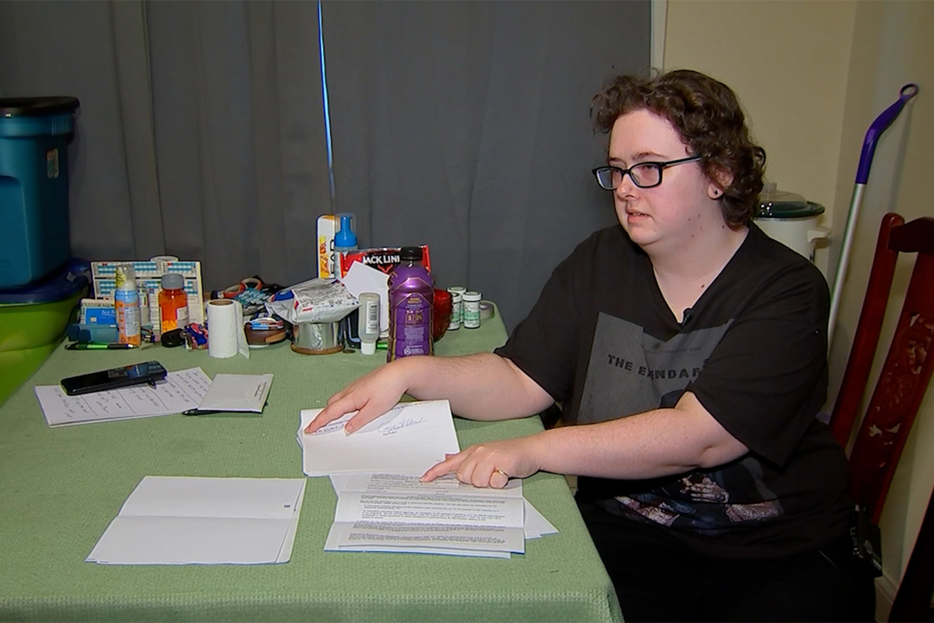 A photo of a woman sitting at a table pointing to a letter from the Social Security Administration.