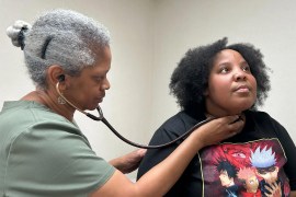 A photo of a doctor examining a female patient.