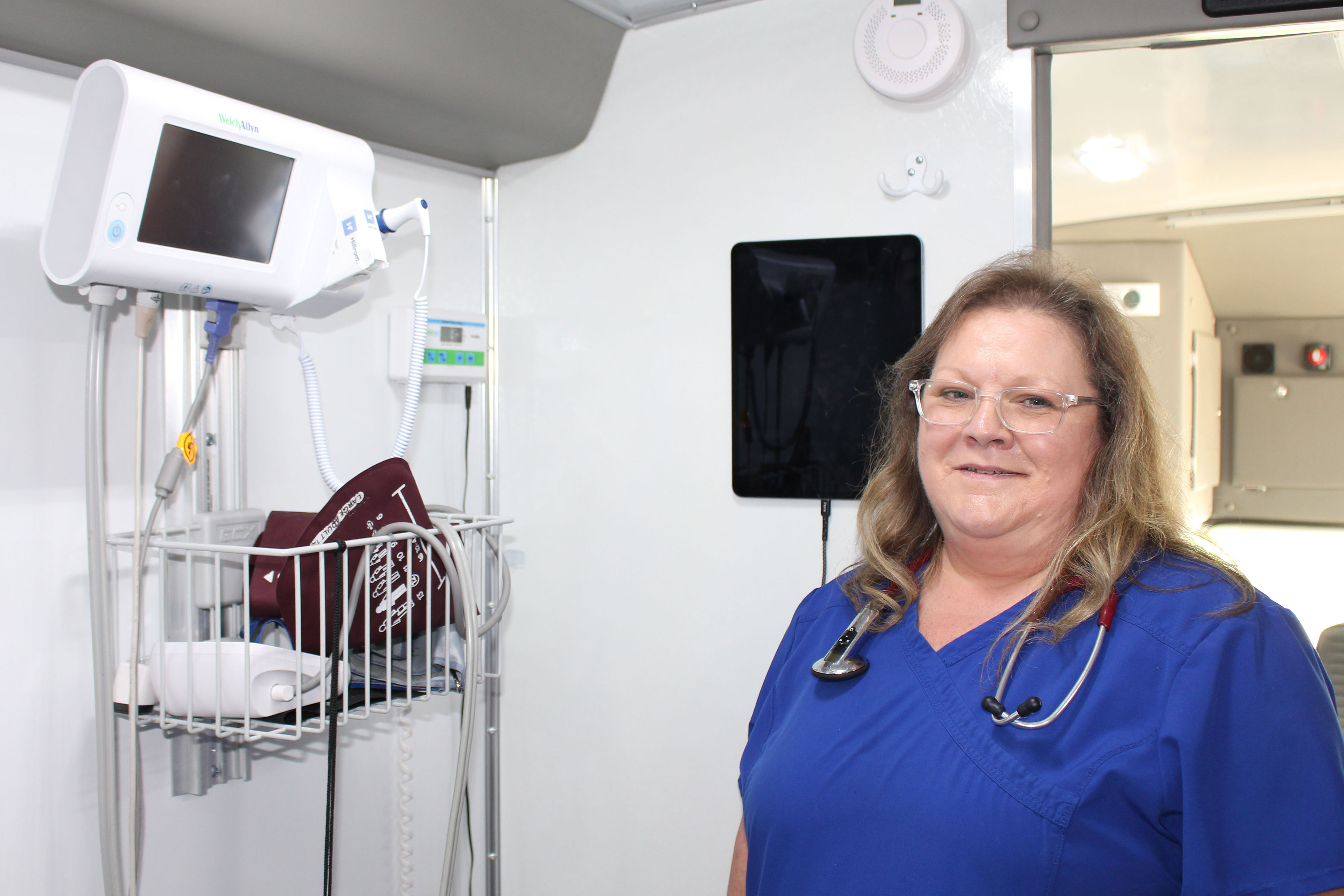 A photo of a nurse standing inside of a mobile health clinic.