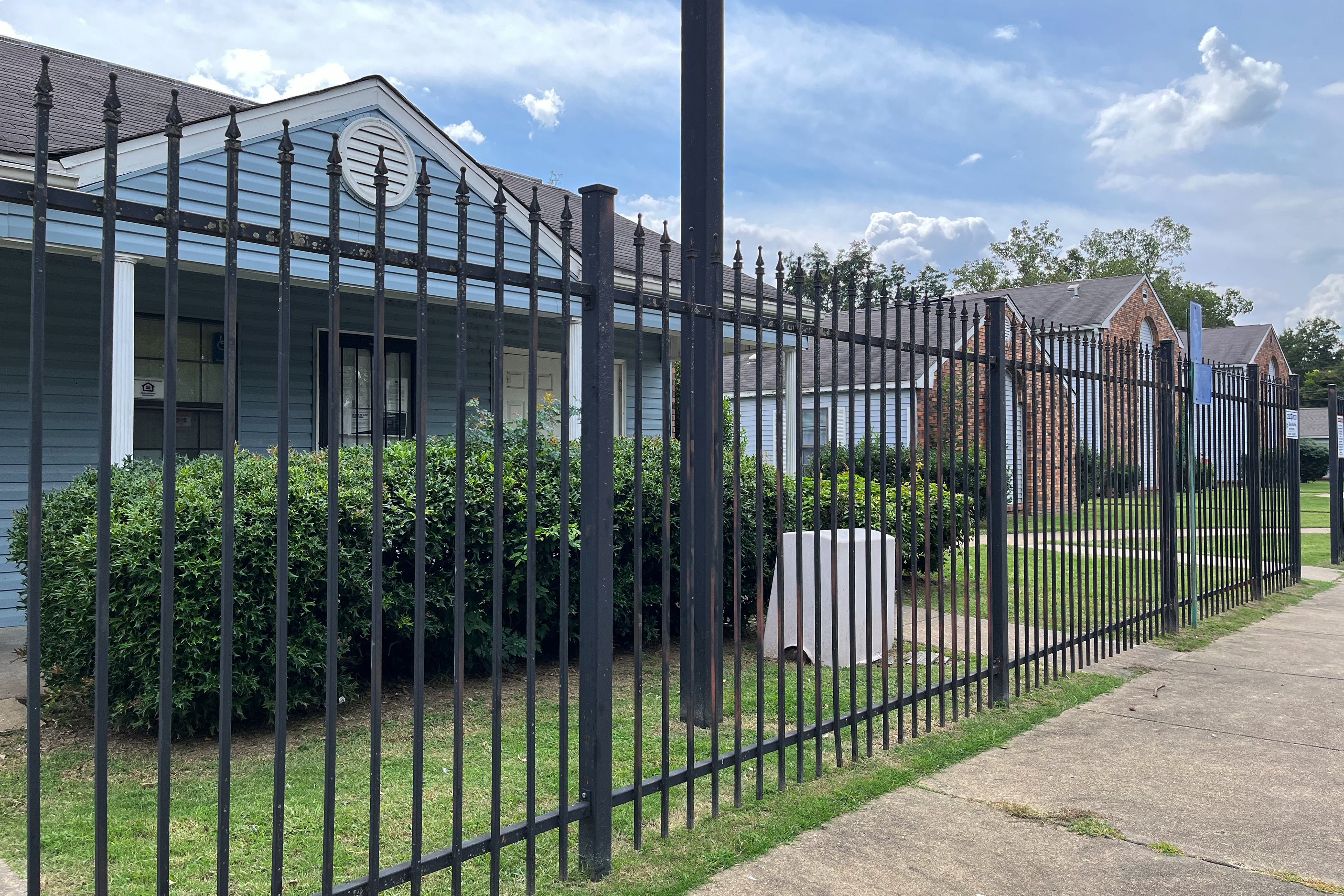 A photo of a housing complex seen behind a fence.
