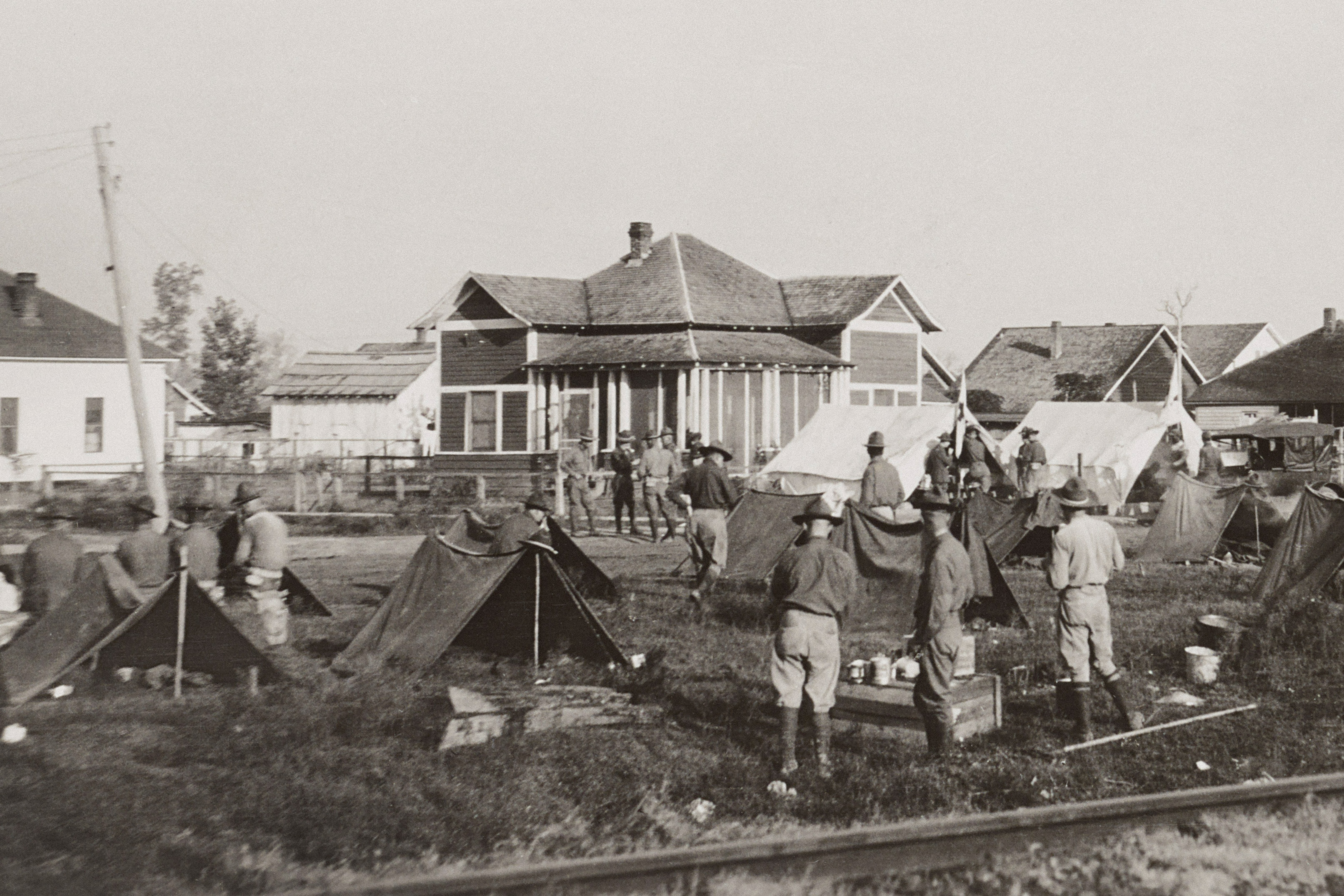 A historic photo from 1919 of soldiers standing in a camp of tents in Elaine, Arkansas.