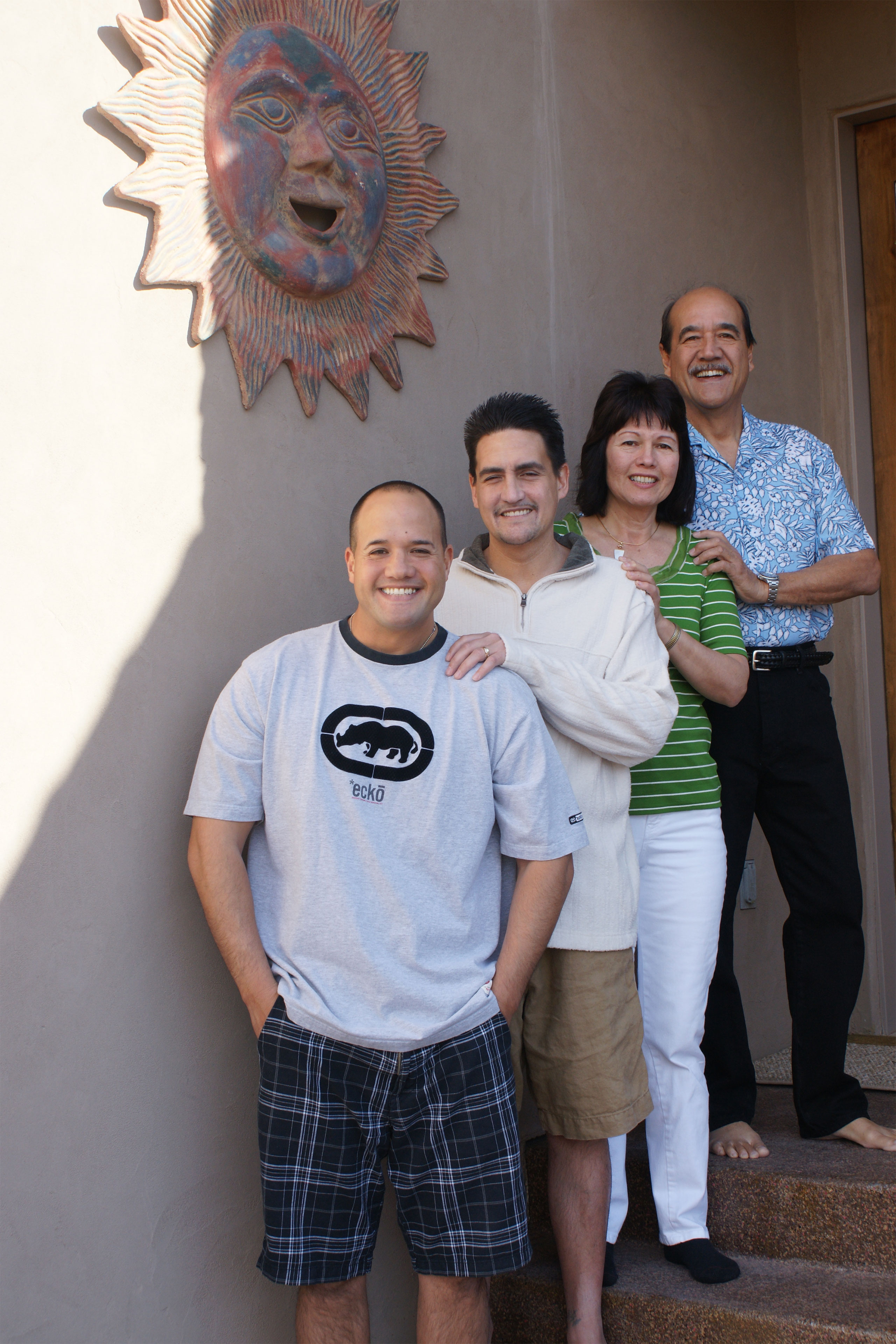 Four people stand together on a short flight of steps.