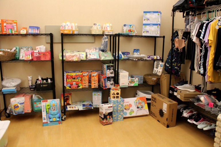 A photo of racks filled with toiletries, children's clothes, games, and tennis shoes.