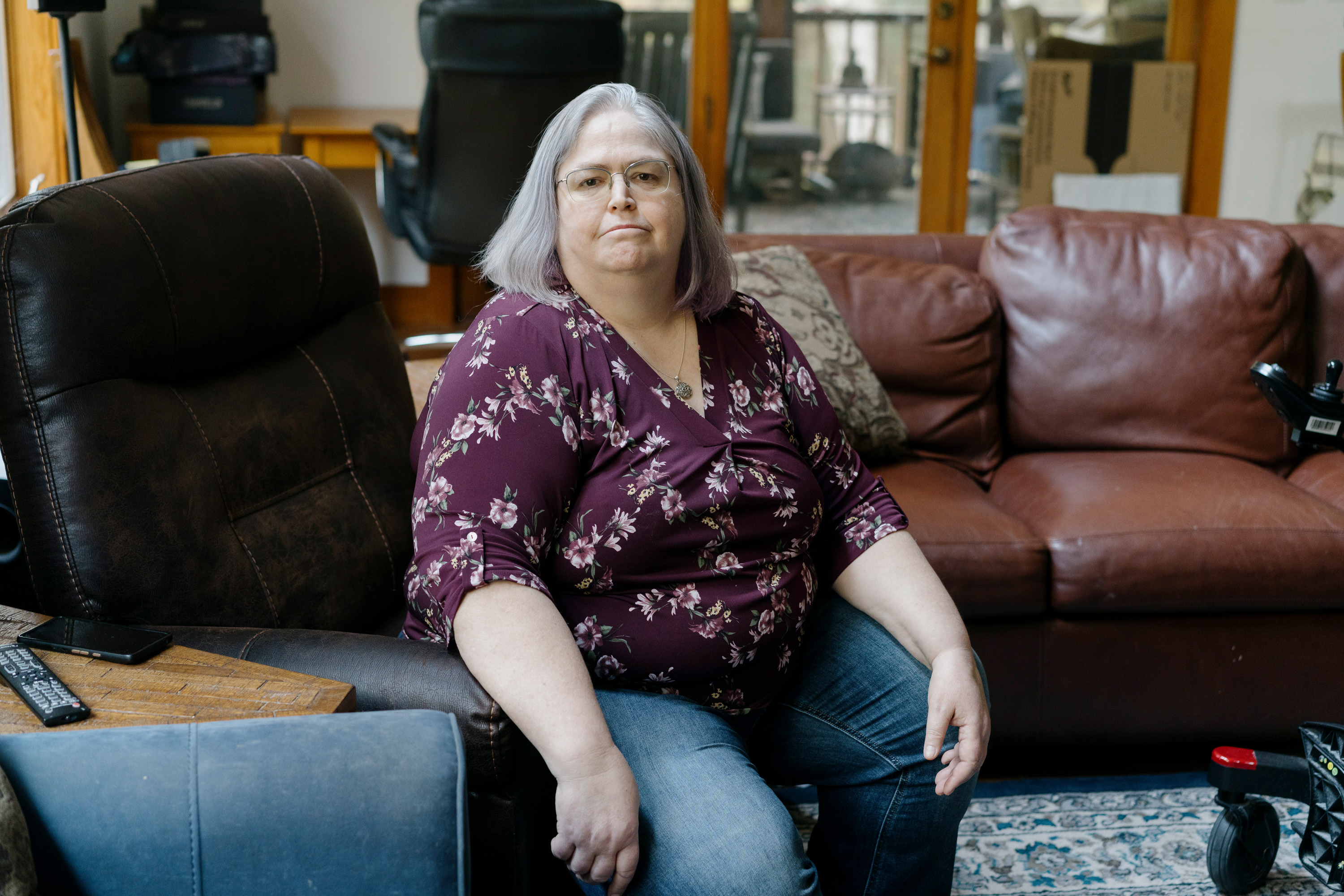 A photo of a woman sitting in a chair indoors.