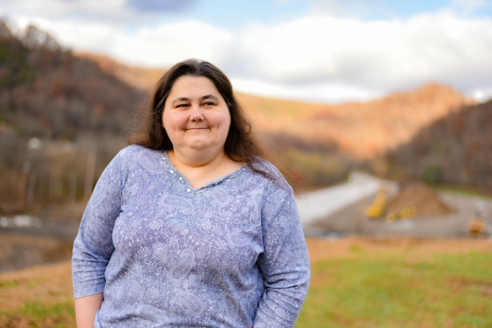 A photo of a woman standing for a portrait outside.